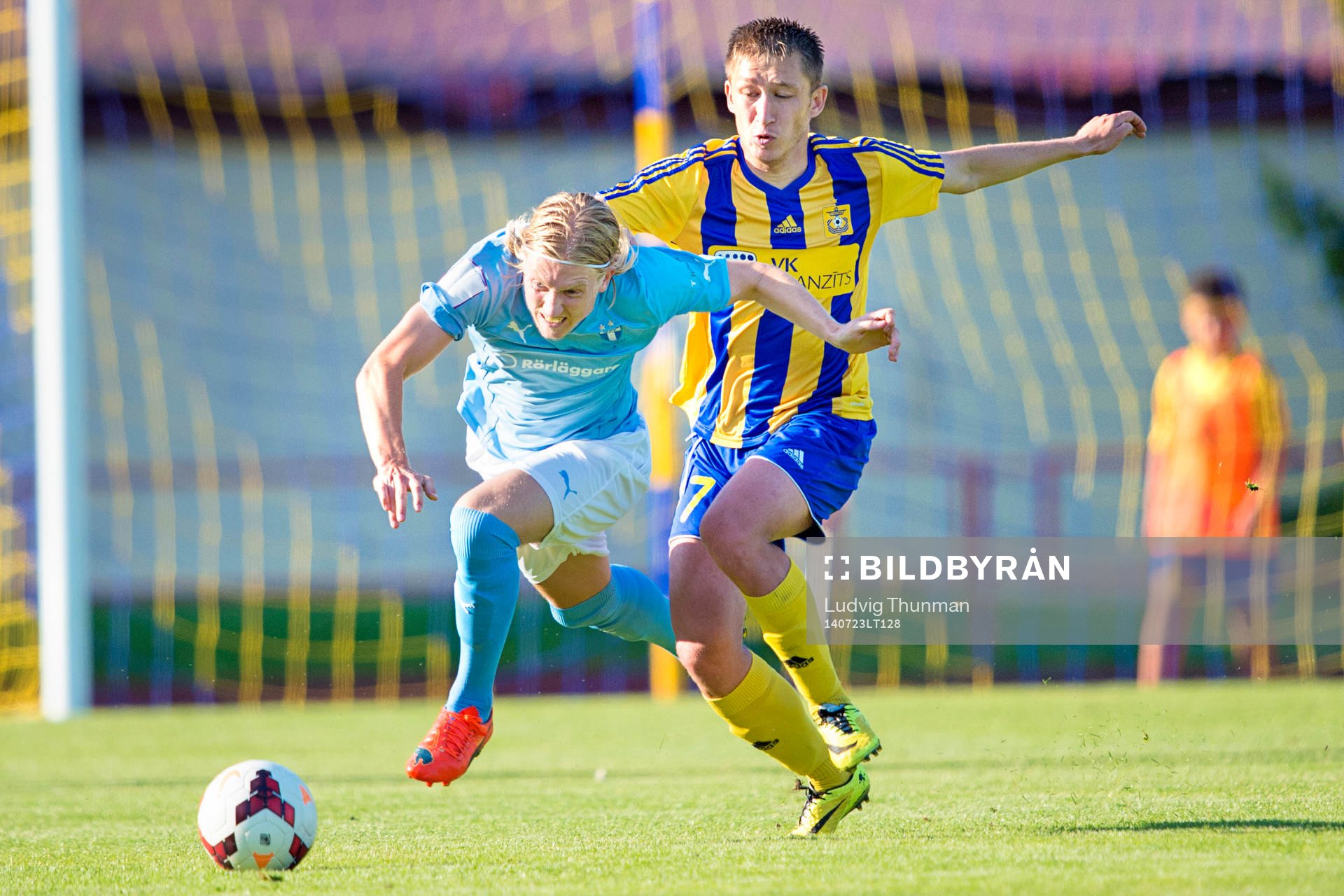 Malmö FFs Simon Kroon faller i en duell mot Ventspils Tornike Tarkhnishvili under kvalmatchen i Champions League mellan FK Ventspils och Malmö FF den 23 juli 2014 i Ventspils.