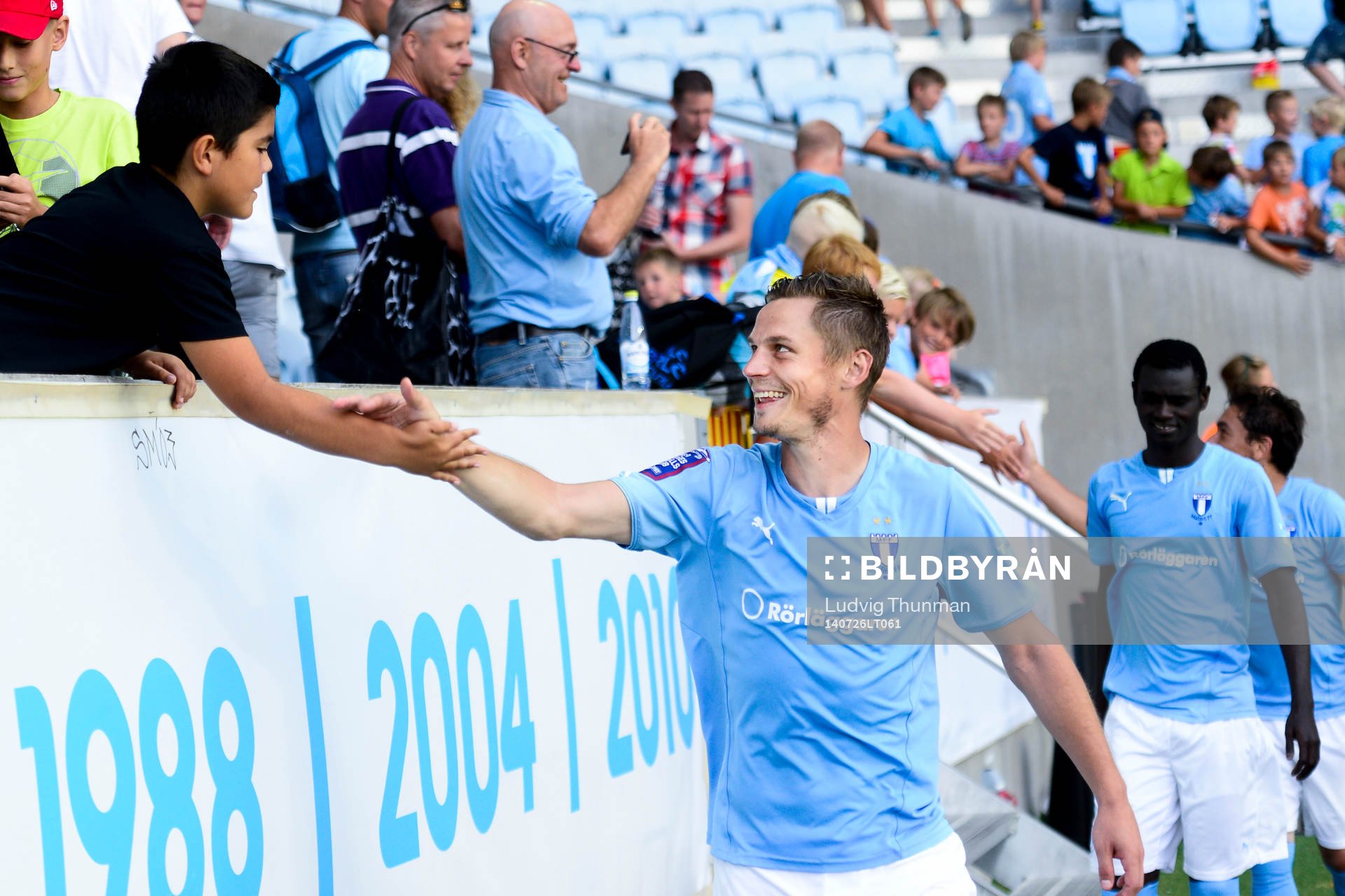 En ung supporter tar i hand med Malmö FFs Markus Rosenberg