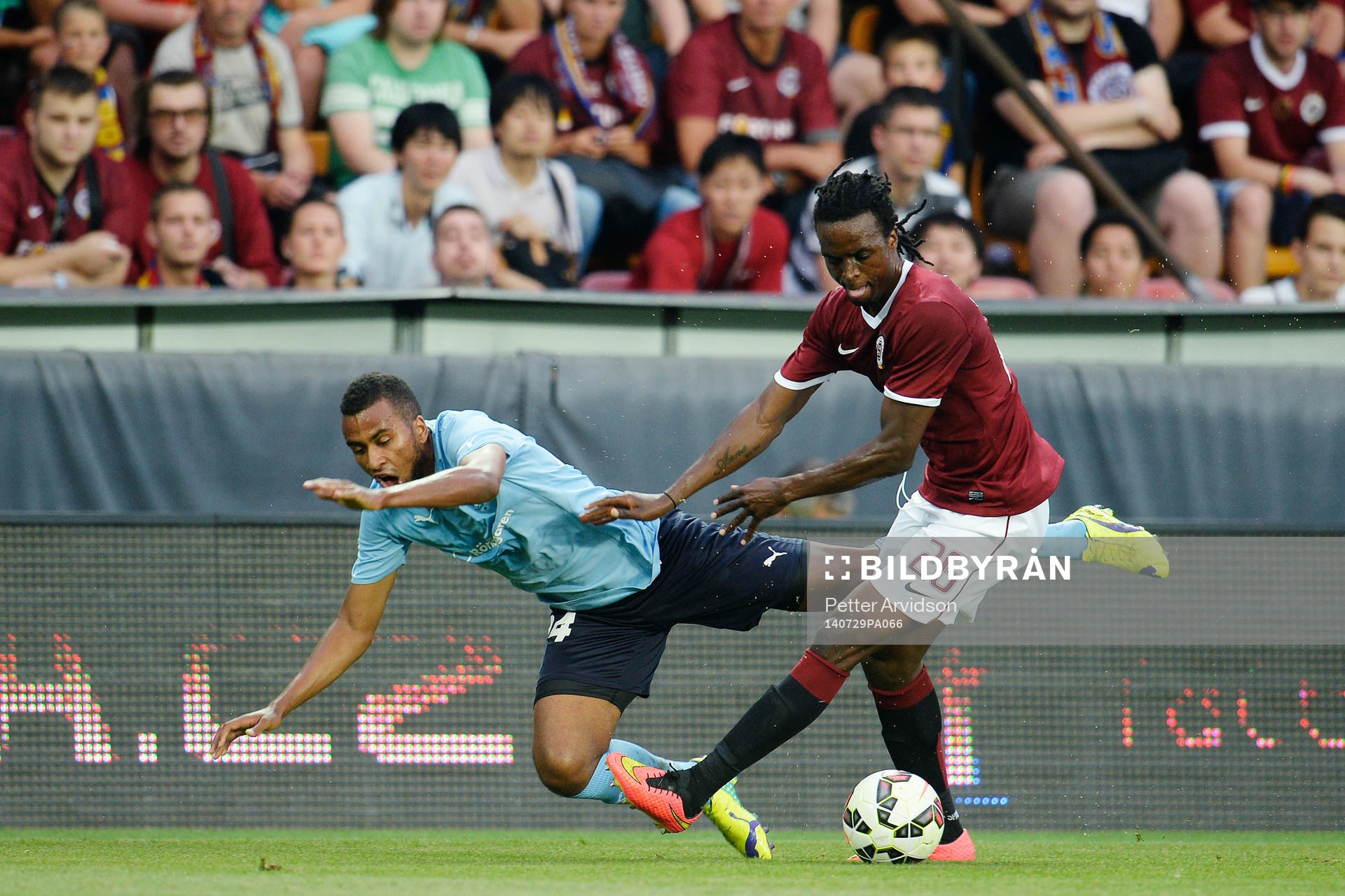 Malmö FFs Isaac Kiese Thelin tacklas ner av Sparta Prags Costa Nhamoinesu under fotbollsmatchen i kvalet till Champions League mellan Sparta Prag och Malmö FF den 29 juli 2014 i Prag.