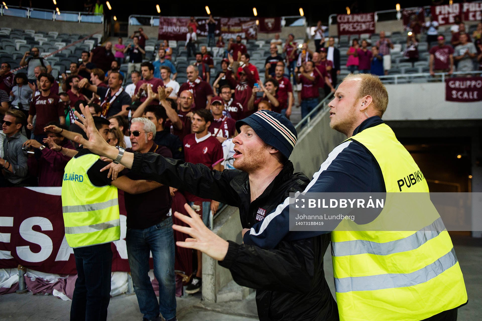 En supporter tar sig ner från läktaren men stoppas av