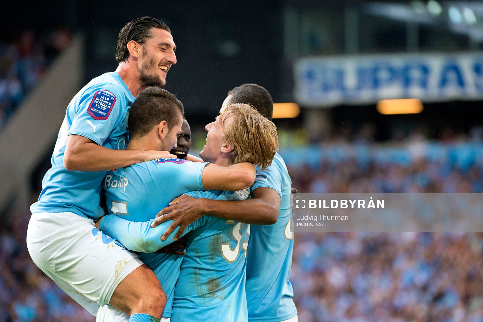 Malmö FFs Agon Mehmeti hoppar upp på ringen av spelare som firar Emil Forsberg gjort 2-1 under matchen i Allsvenskan mellan Malmö FF och IFK Göteborg den 10 augusti 2014 i Malmö.