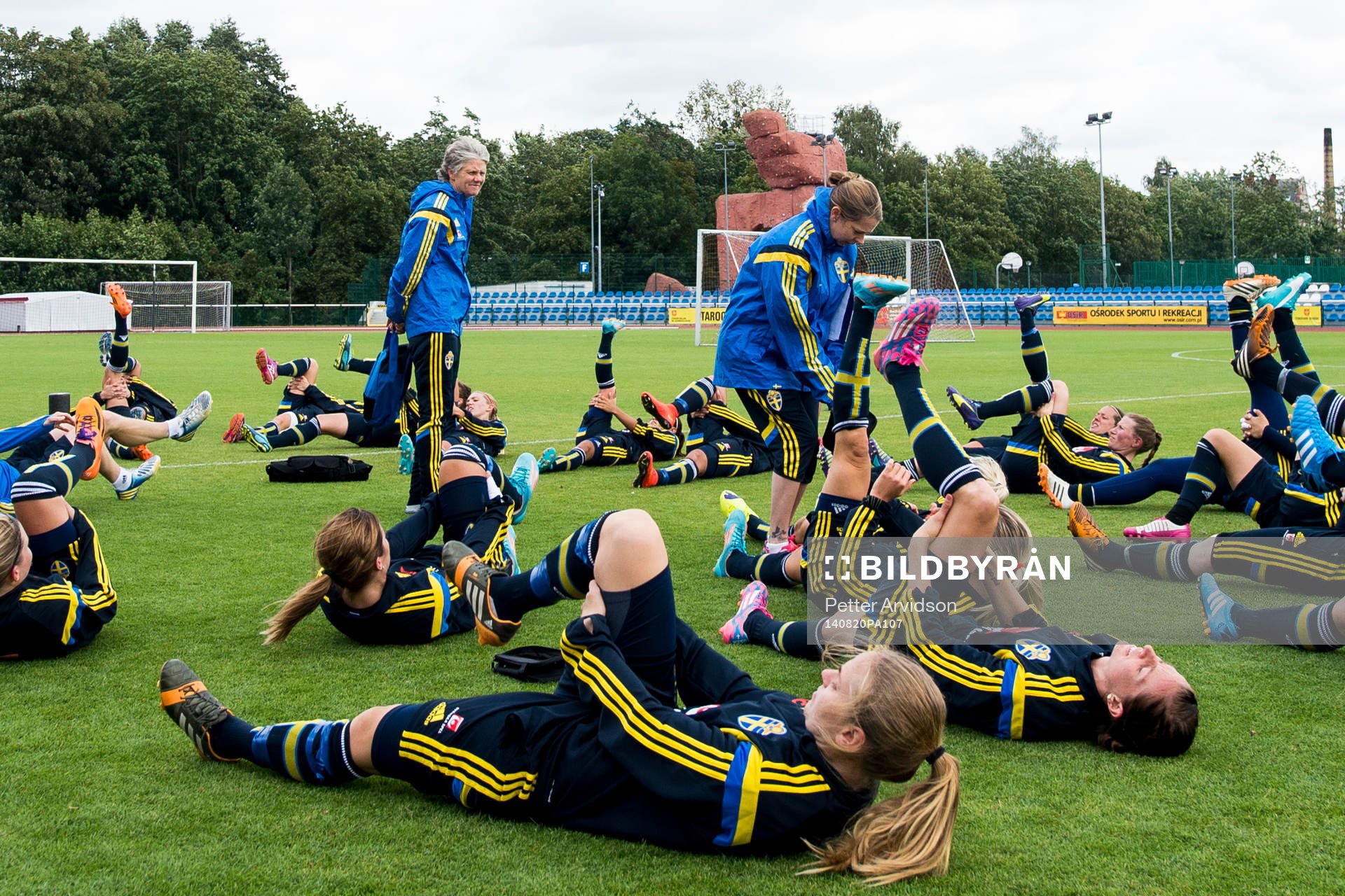 Sveriges förbundskapten Pia Sundhage står i mitten när spelarna stretchar efter en träning inför VM-kvalmatchen mot Polen den 20 augusti 2014 i Gdansk.