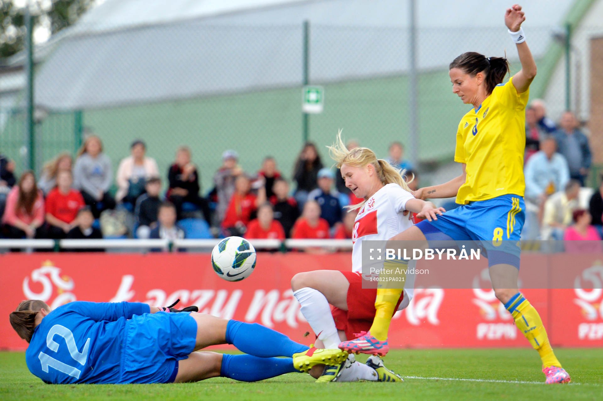 Sveriges Lotta Schelin i kamp med Polens Magdalena Szaj och målvakt Anna Szymanska under fotbollsmatchen i VM-kvalet mellan Polen och Sverige den 21 augusti 2014 i Starogard Gdansk.