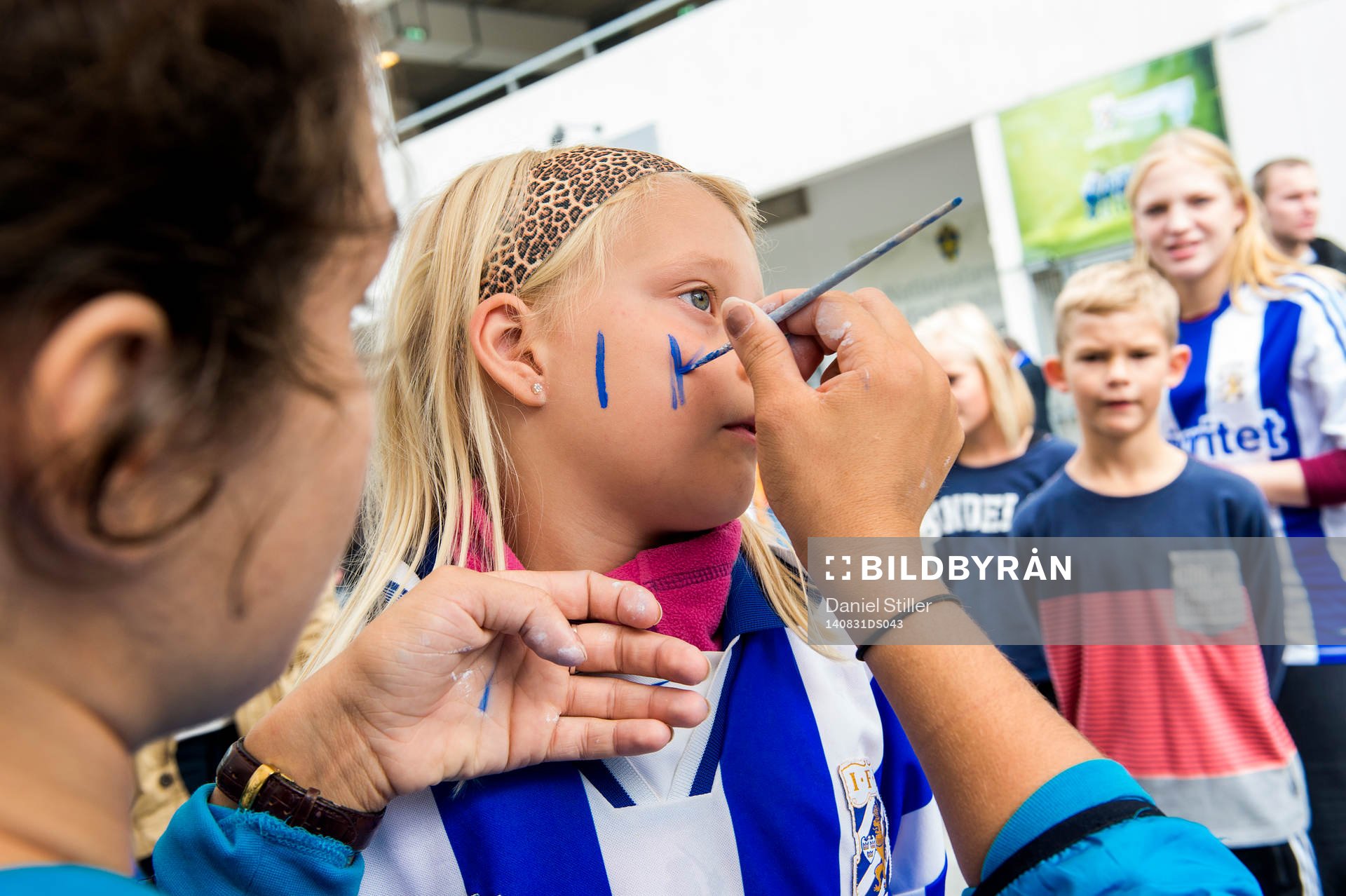 En ung IFK Göteborgssupporter blir målad innan