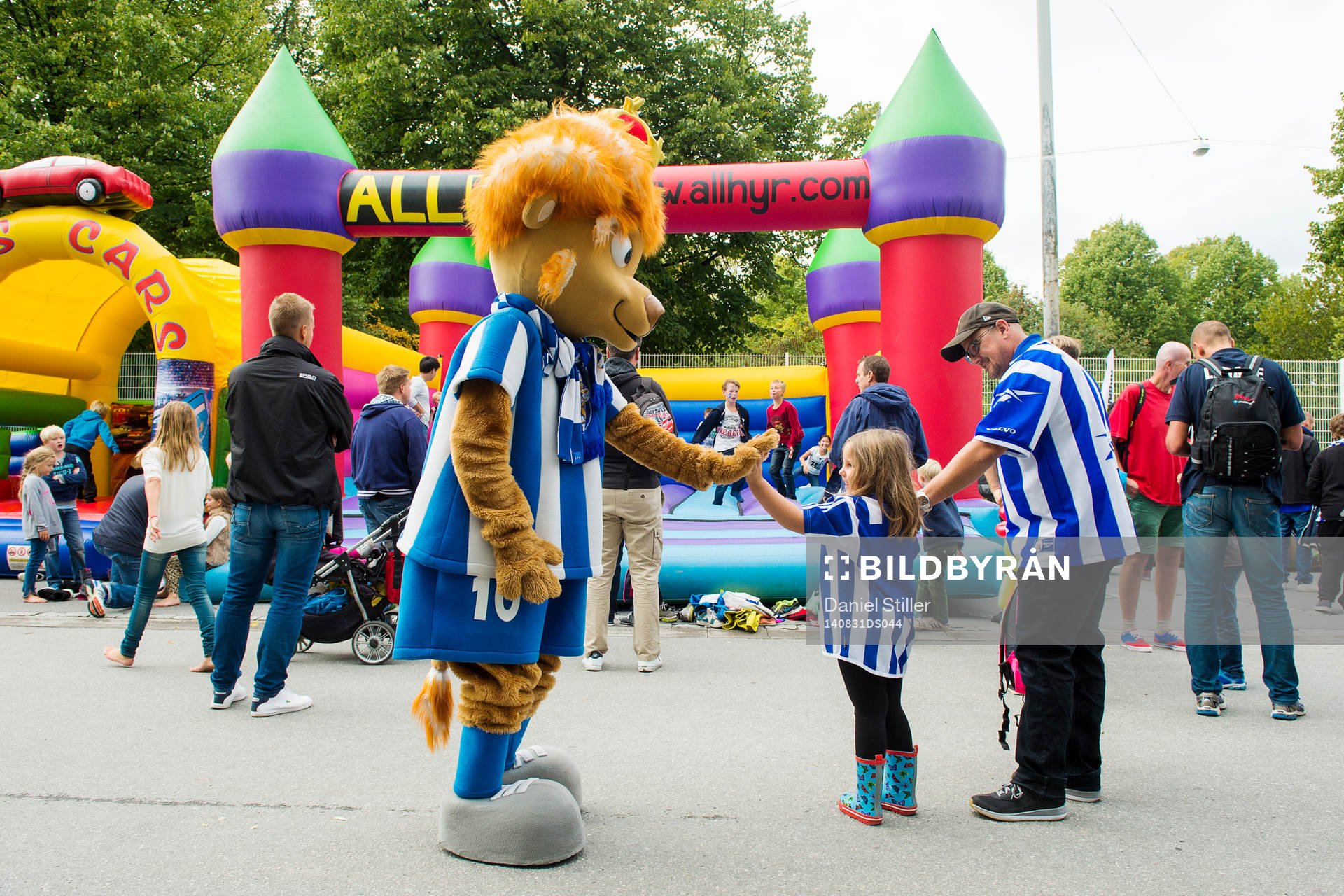 Maskoten Leo med en ung supporter innan fotbollsmatchen i
