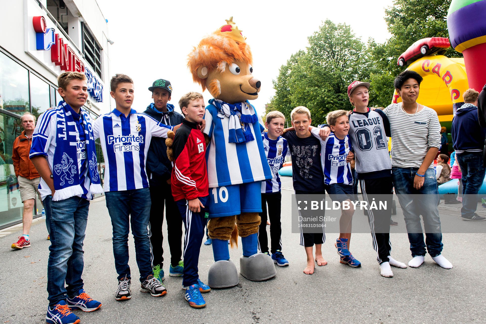 Unga supportrar med maskoten Leo innan fotbollsmatchen i