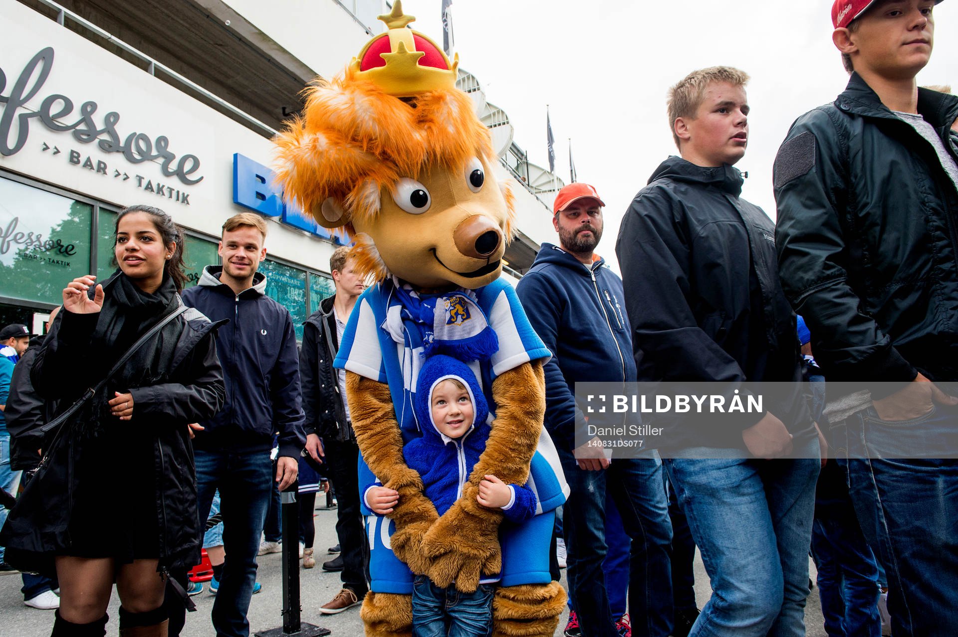 Maskoten Leo med unga supportrar innan fotbollsmatchen i