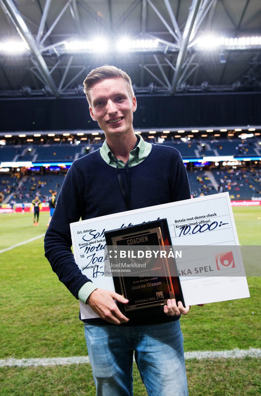 Joakim Olsson poserar med ett diplom och check från