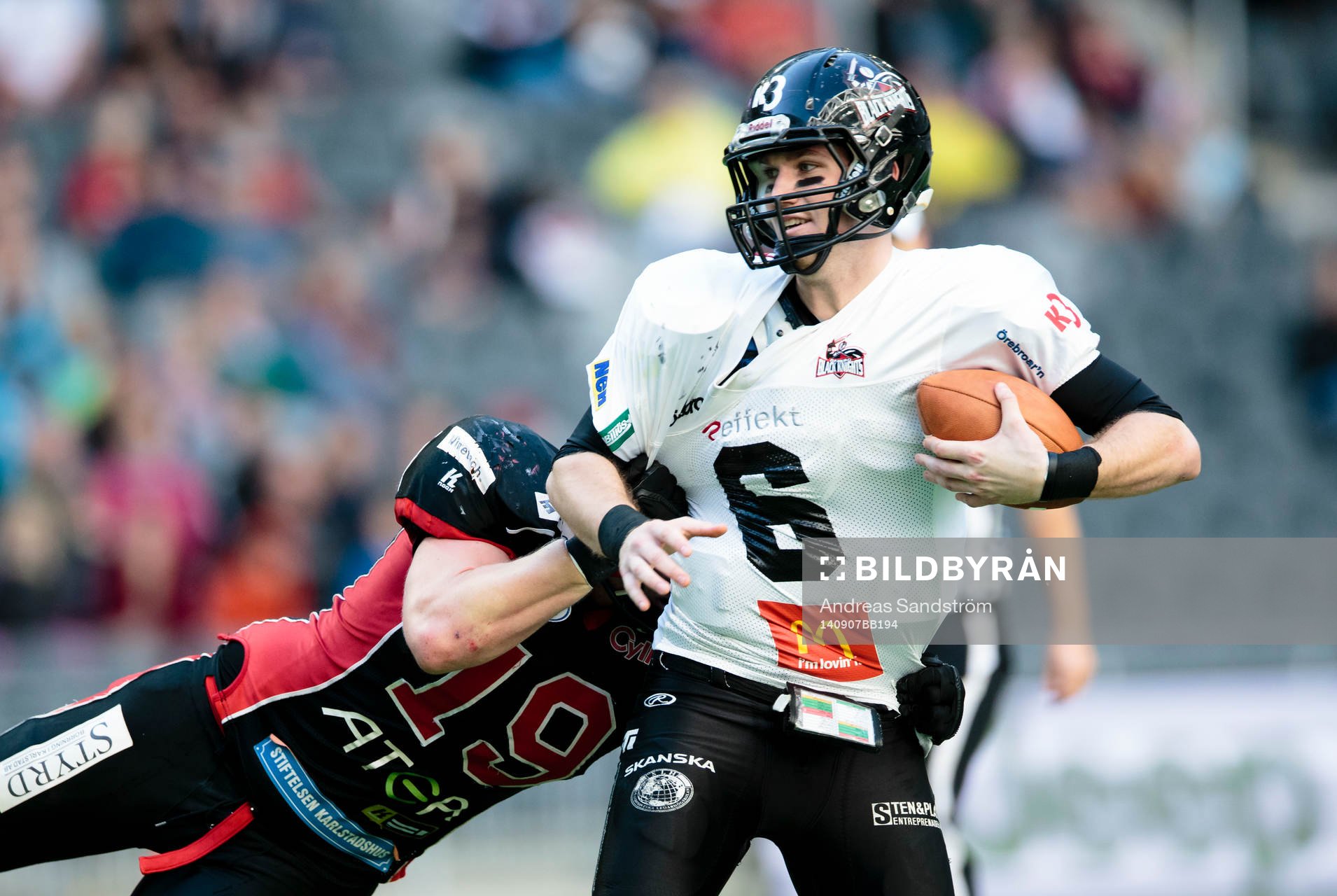 Örebro Black Knights quarterback Joe Clancy hålls i tröjan av Carlstad Crusaders Olof Flemström under SM-Final XXIX i Amerikansk fotboll mellan Carlstad Crusaders och Örebro Black Knights den 7 September 2014 i Stockholm.