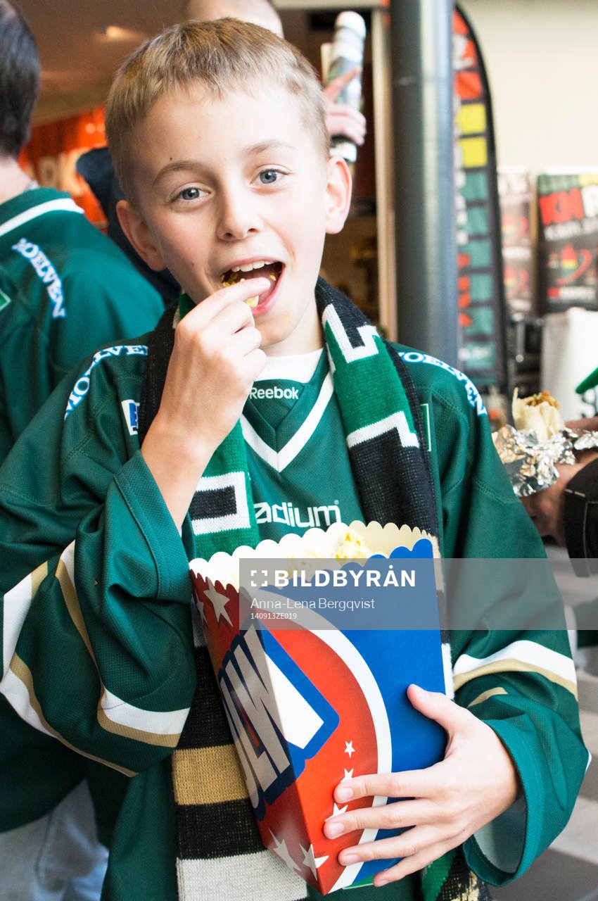 Ung supporter äter popcorn innan ishockeymatchen i SHL