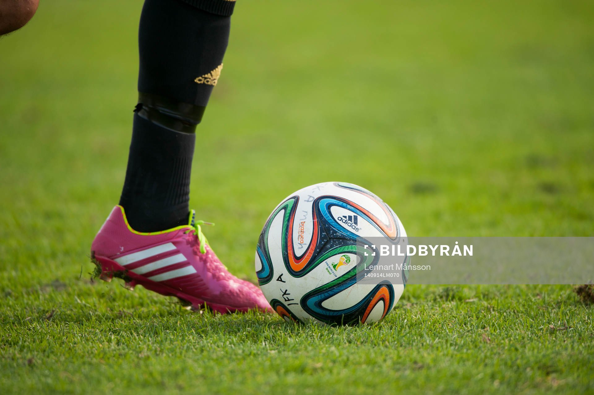 Fotbollsskor Adidas och fotboll Adidas i matchen i