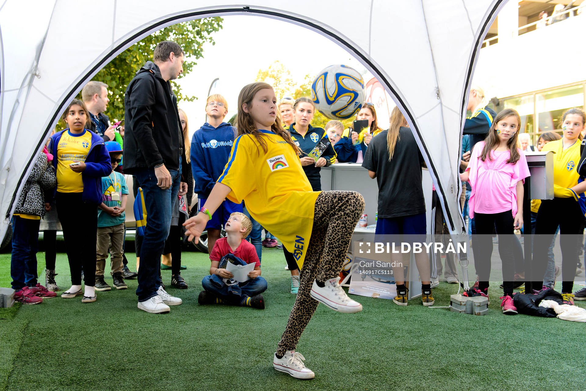 En tjej kickar boll i fan-zone