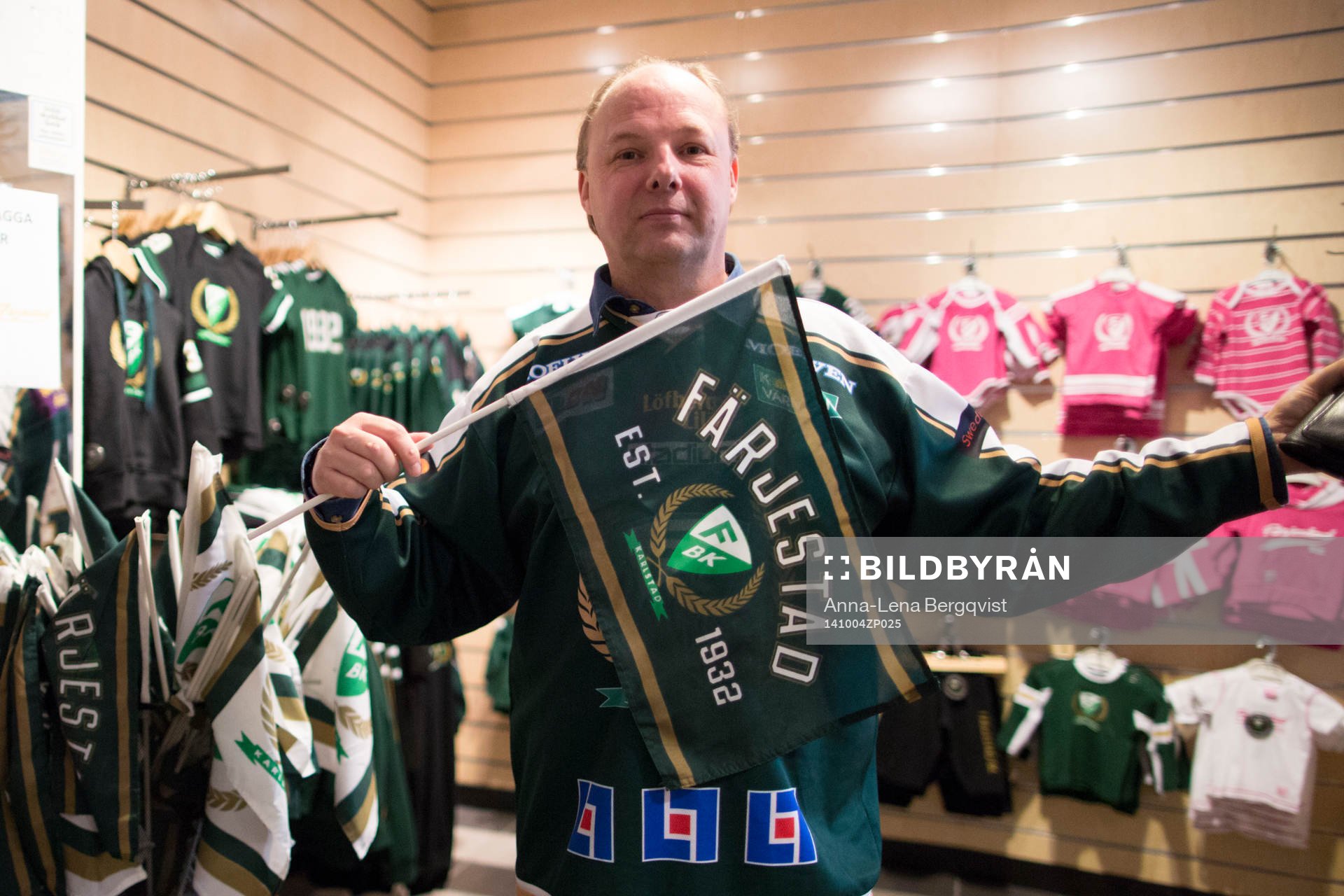 En Färjestadssupporter visar upp flaggor i butiken