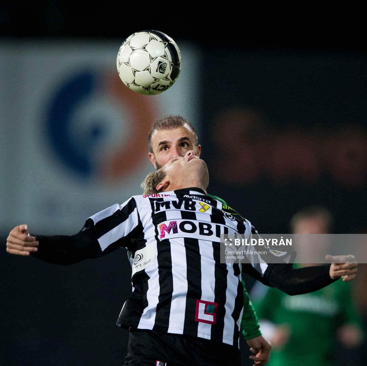 Hammarbys Kennedy Bakircicioglu tittar fram bakom en nickande Landskrona-spelare i matchen i superettan mellan Landskrona och Hammarby i Landskrona 5 oktober 2014.