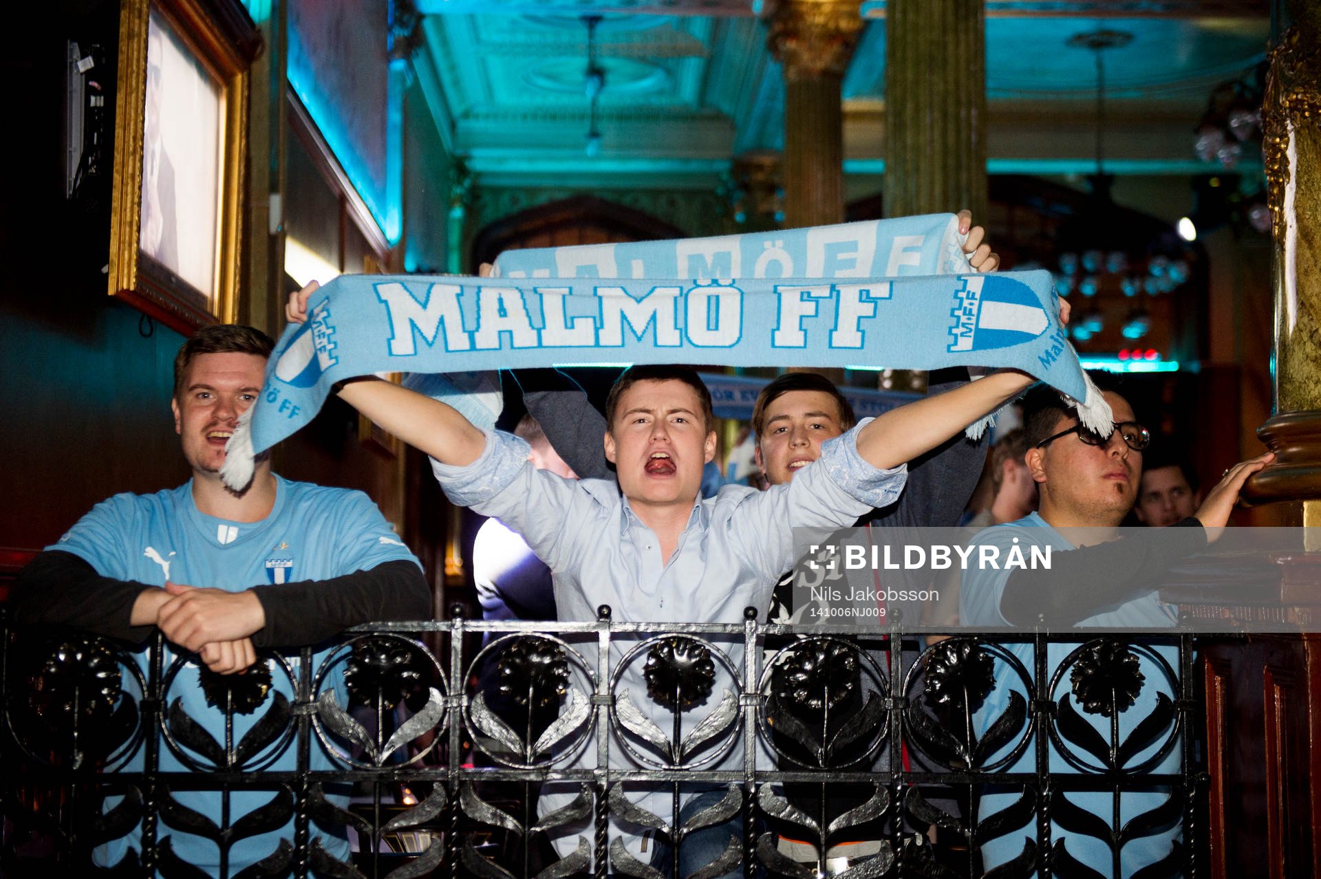 En supporter med halsduk jublar när Malmö FF firar sitt