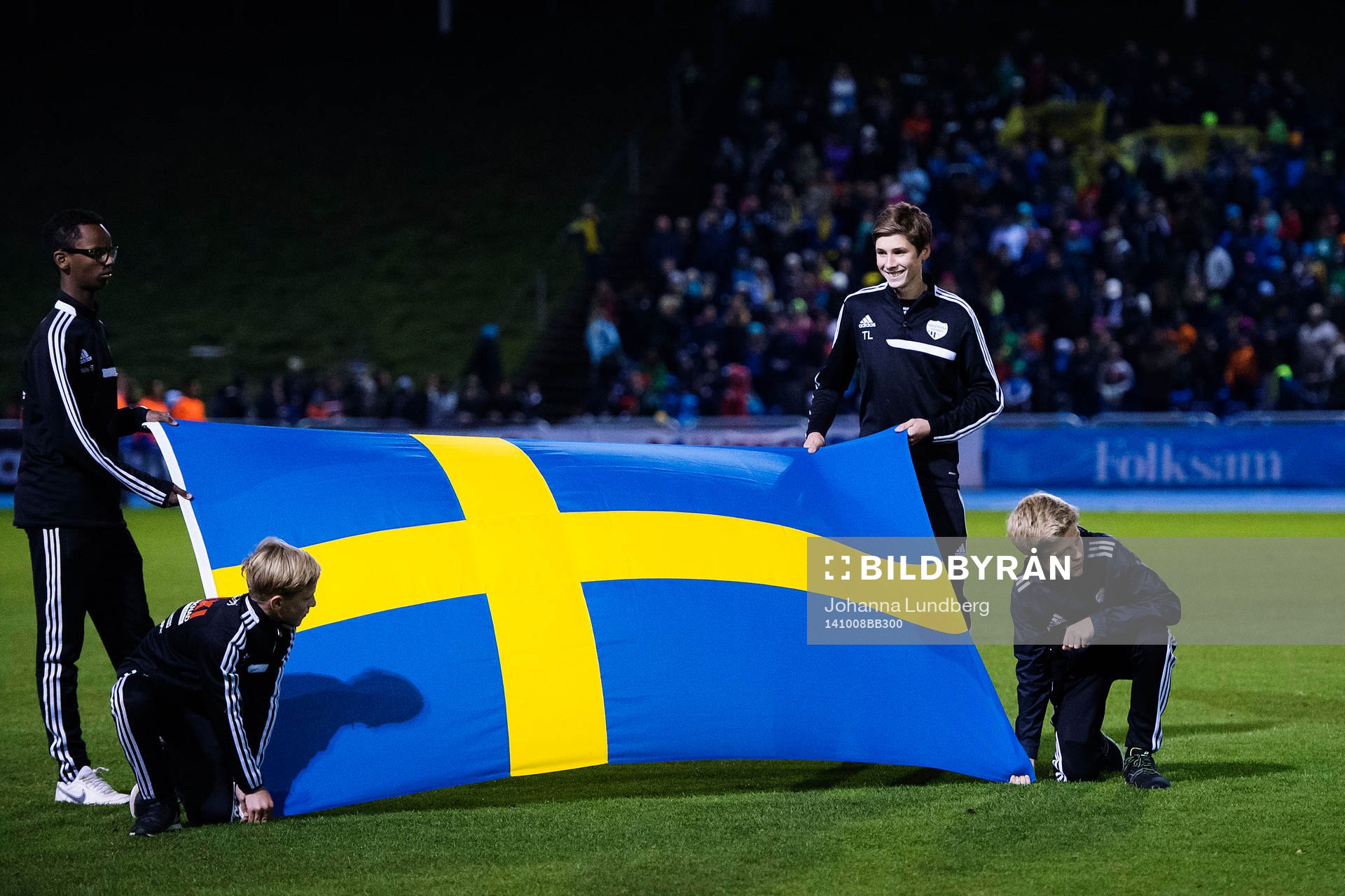 Några ungdomar håller i en svensk flagga