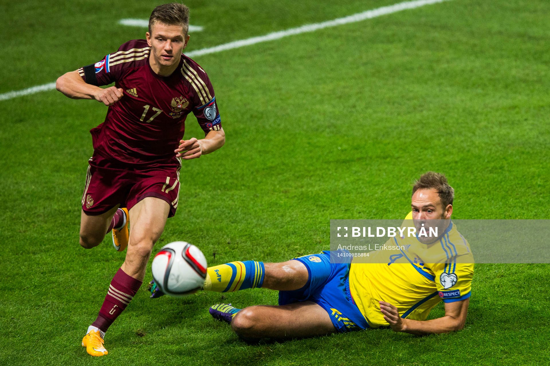 Sveriges Andreas Granqvist rensar undan bollen för Rysslands Oleg Shatov under fotbollsmatchen i EM-kvalet mellan Sverige och Ryssland den 9 oktober 2014 i Stockholm.