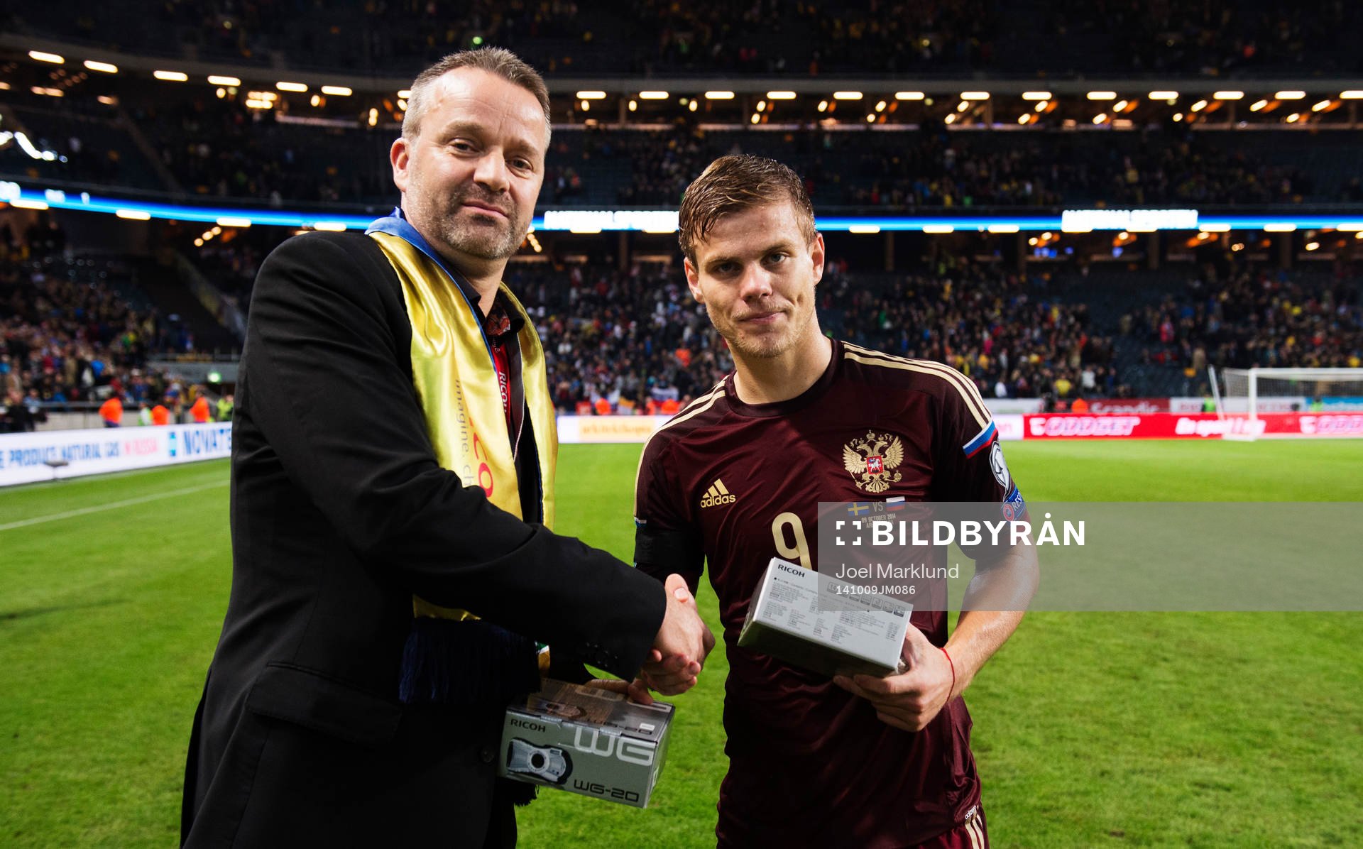 Rysslands Aleksandr Kokorin tar emot pris för det svenska lagets bästa spelare av en representant från Ricoh efter fotbollsmatchen i EM-kvalet mellan Sverige och Ryssland den 9 oktober 2014 i Stockholm.