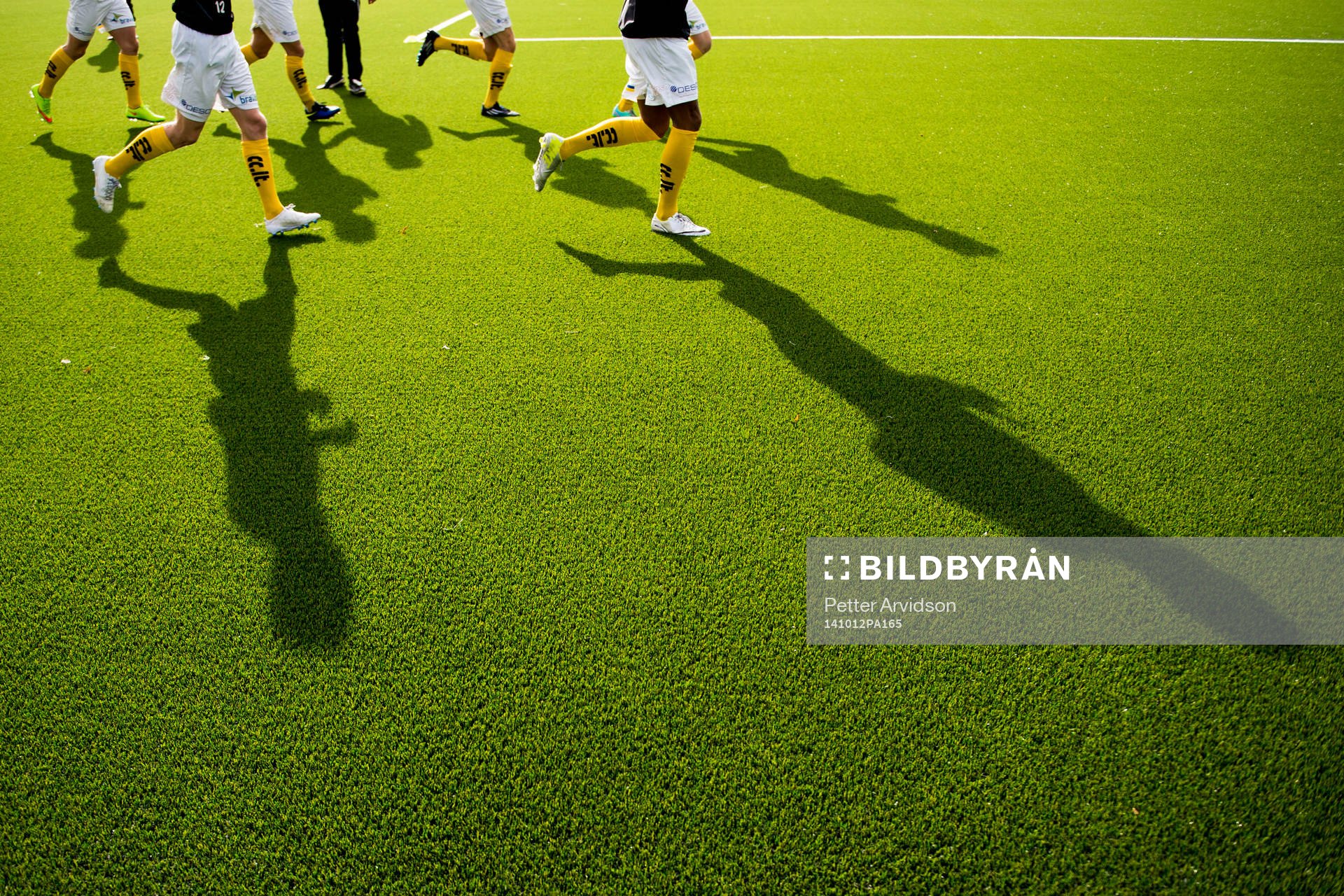 Skuggor av fotbollsspelare som värmer upp på konstgräs inför fotbollsmatchen i Division 1 södra mellan Lunds BK och Trelleborg den 12 oktober 2014 i Lund.