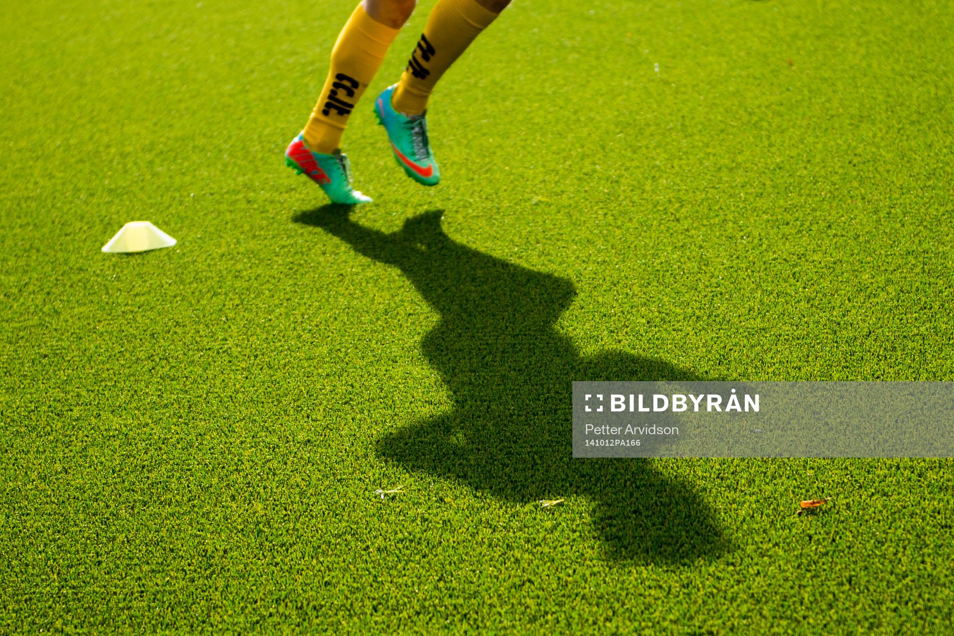 Skugga av en fotbollsspelare som värmer upp på konstgräs inför fotbollsmatchen i Division 1 södra mellan Lunds BK och Trelleborg den 12 oktober 2014 i Lund.