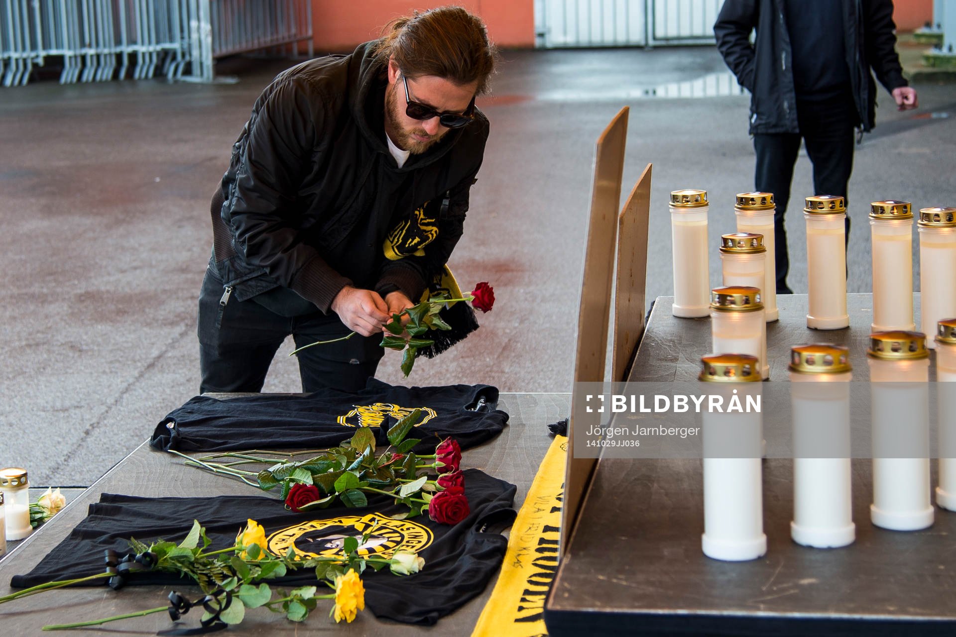 Supporter lägger ner en röd ros och tröja från