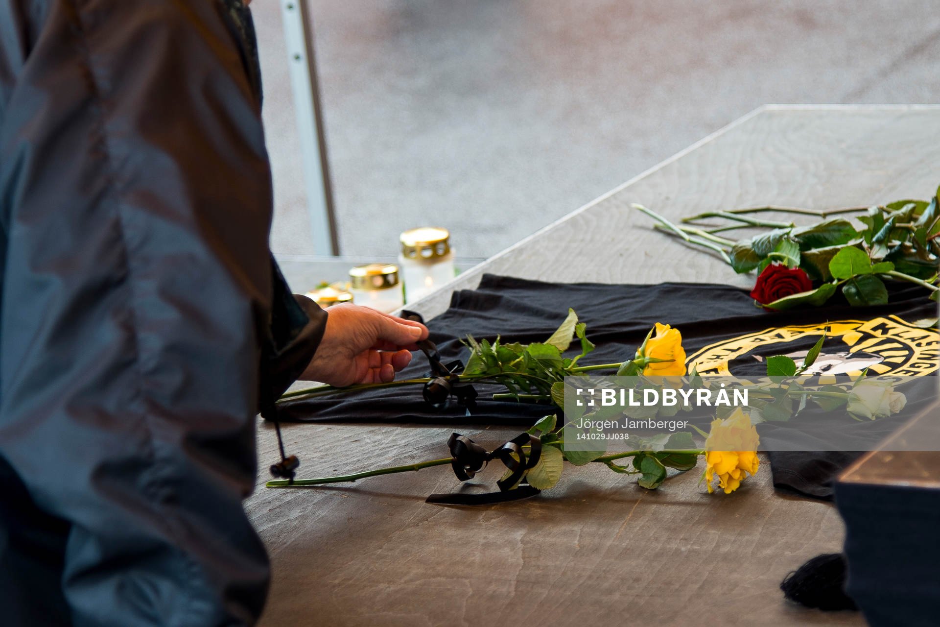 Sörjande supporter lägger ner en gul ros