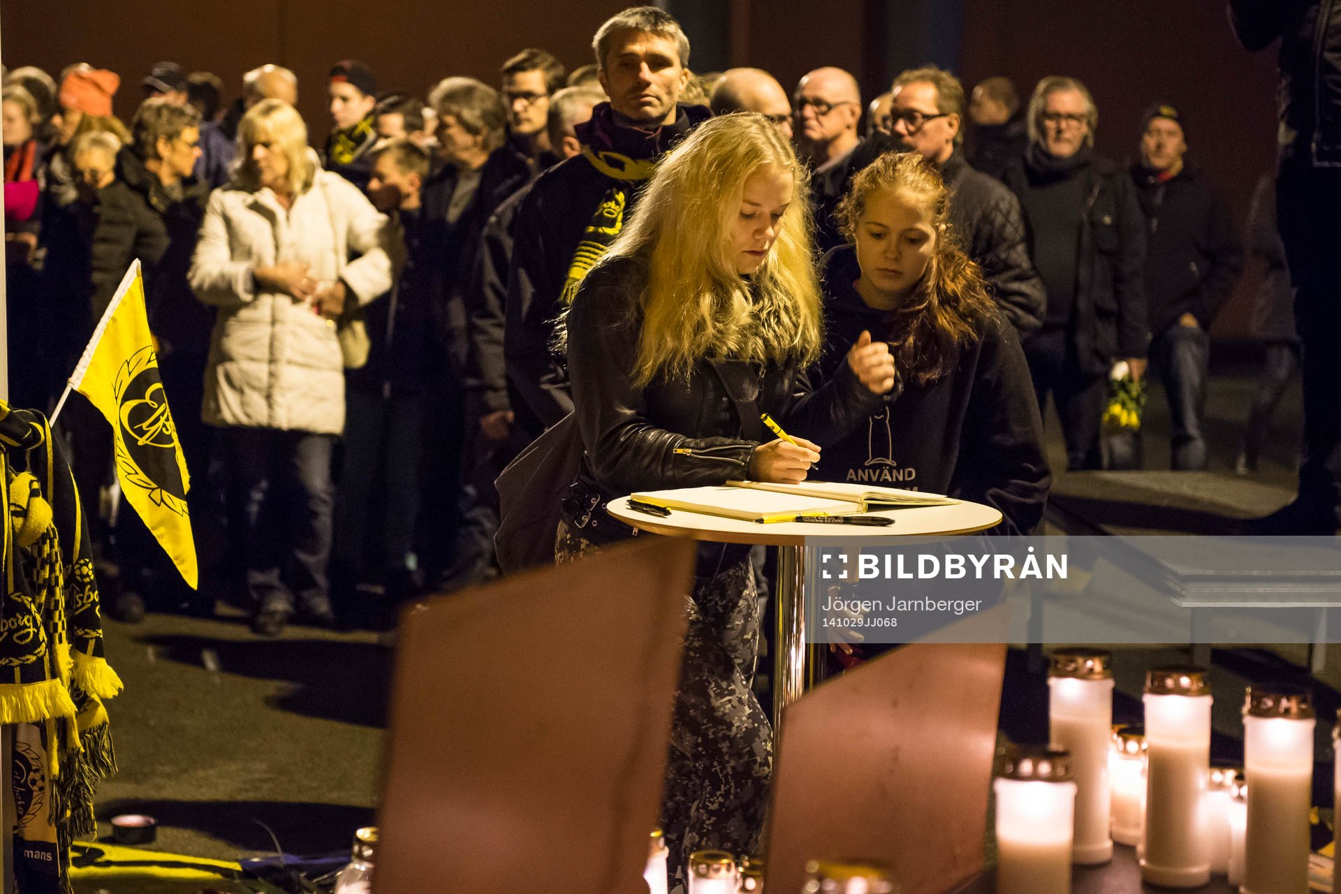 Sörjande skriver i kondoleansboken vid minnesplatsen