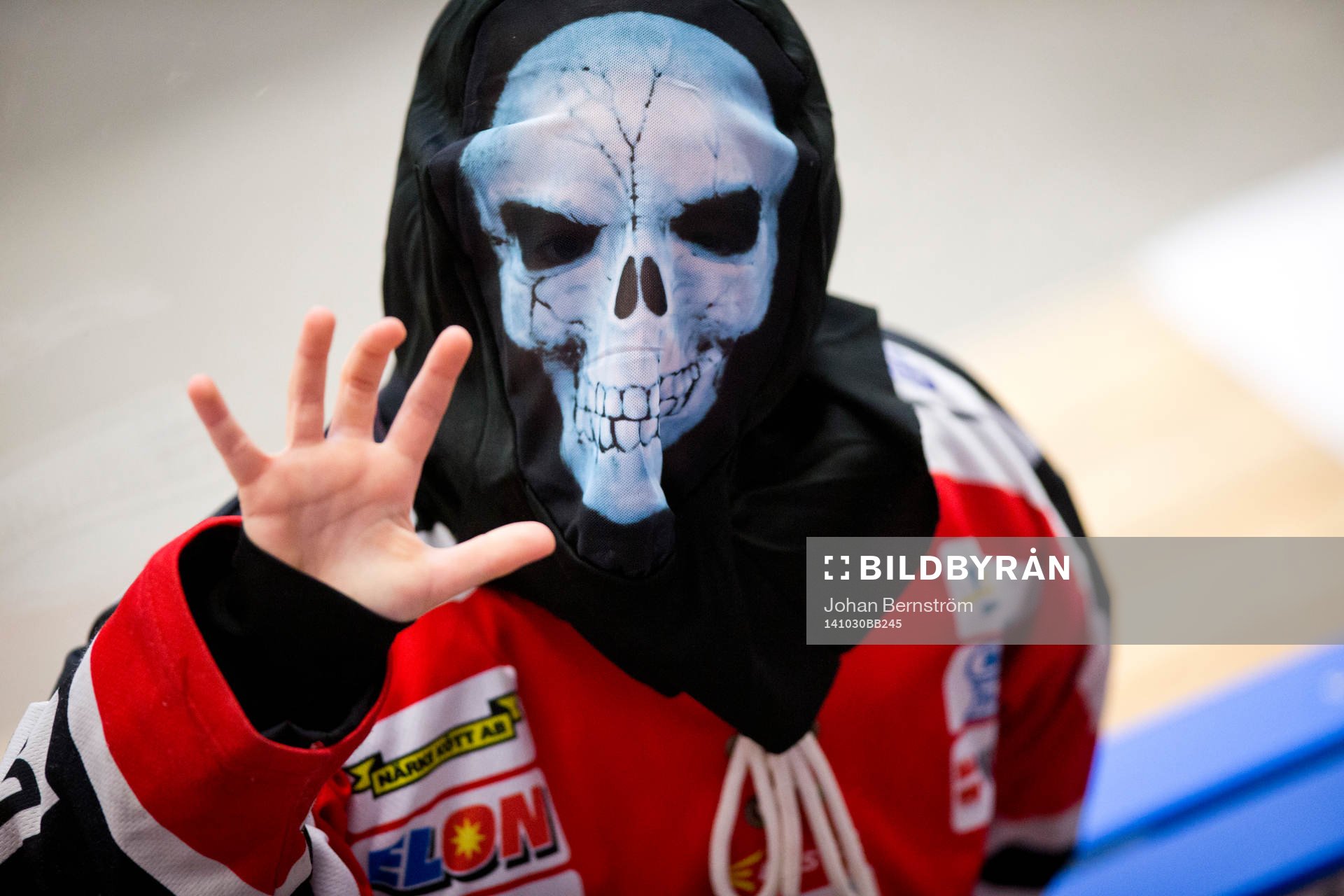 En ung supporter med Örebrotröja och Halloweenmask