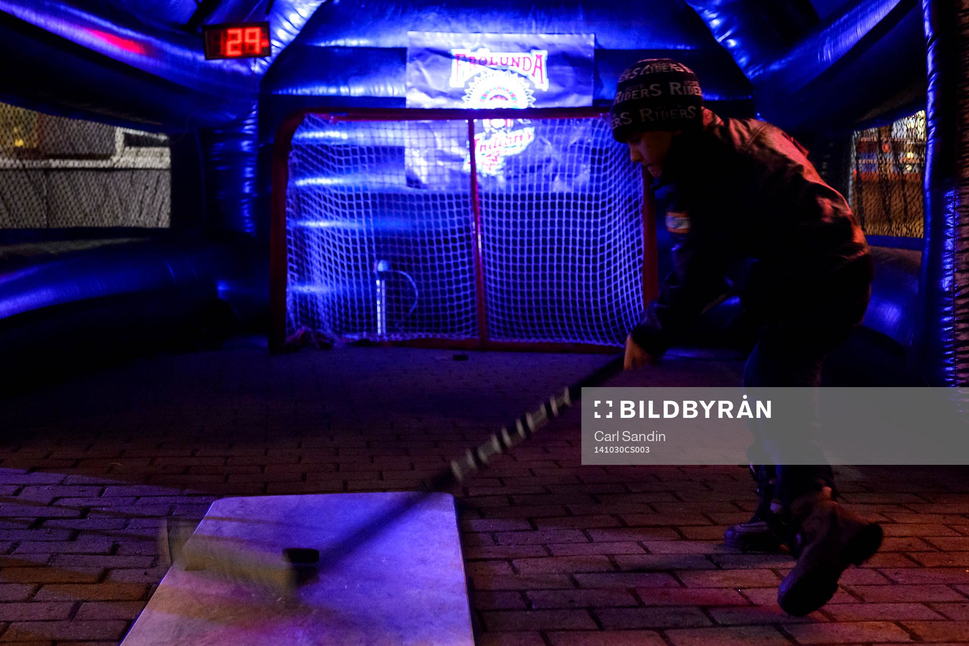 En kille skjuter en puck utanför arenan