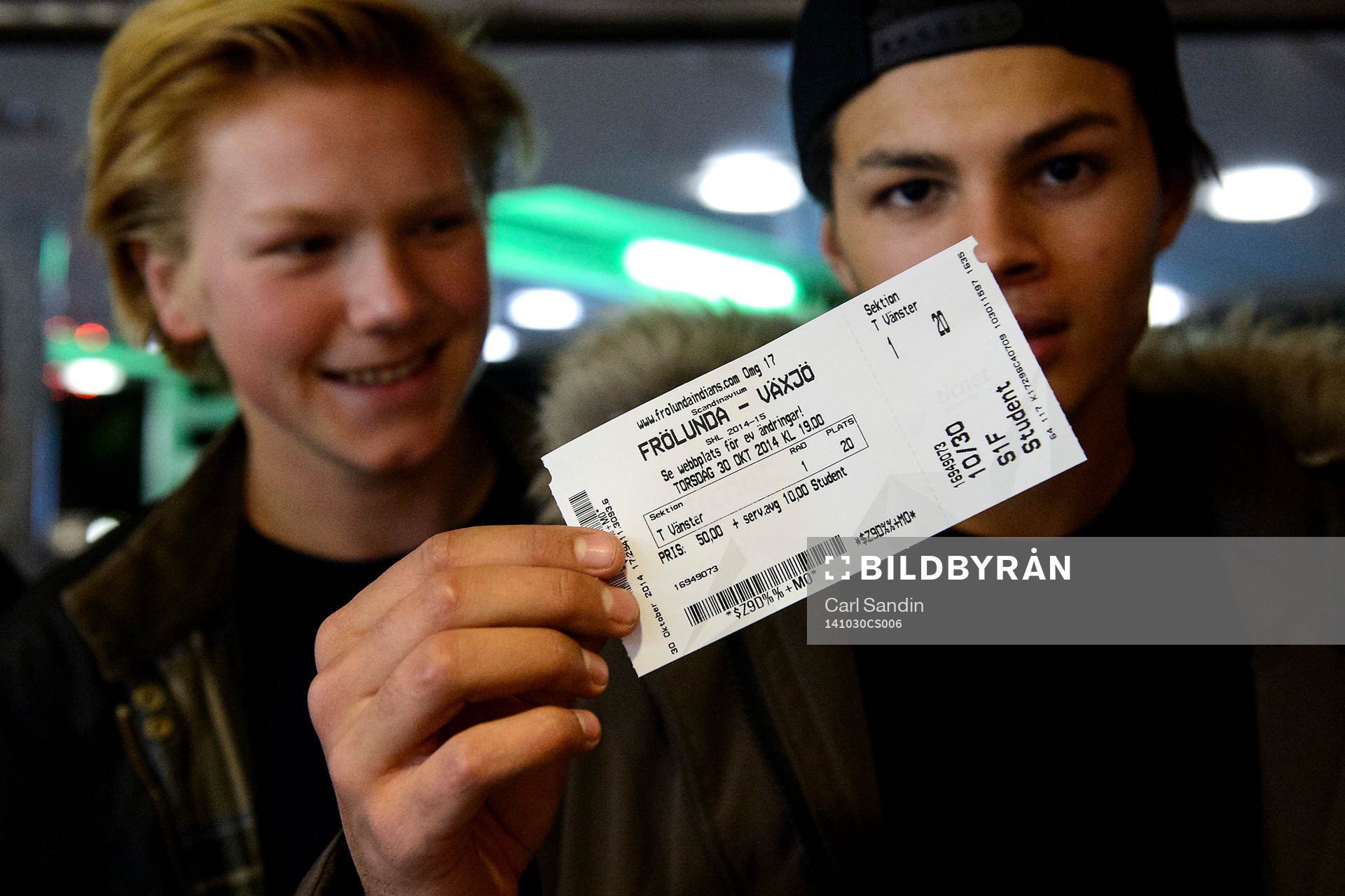 En kille håller en biljett för hockeymatchen i SHL mellan