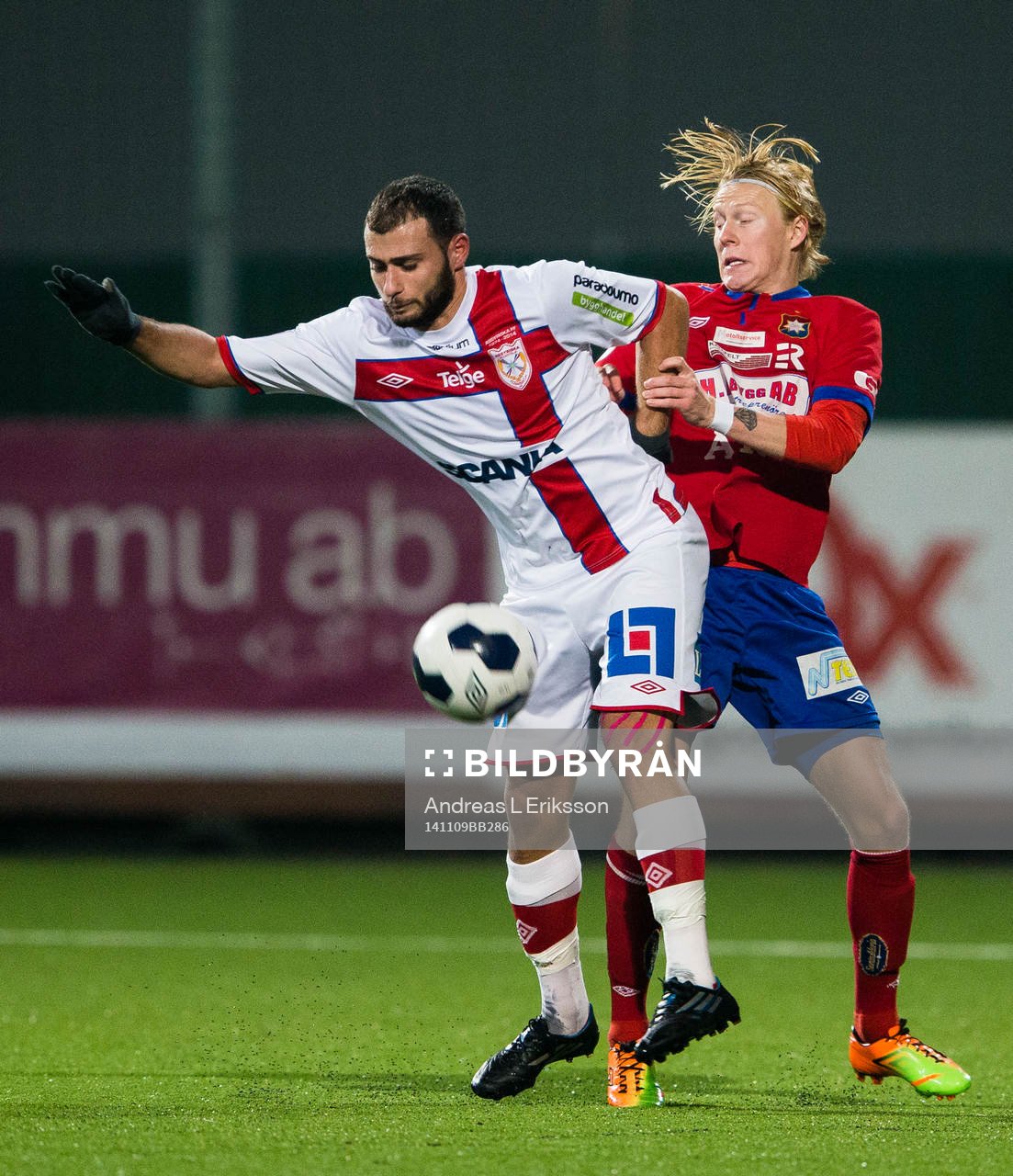 Assyriskas Mattias Genc i kamp om bollen med Örgrytes Jacob Ericsson under fotbollsmatchen i kvalet till Superettan mellan Assyriska och Örgryte den 9 november 2014 i Stockholm. 