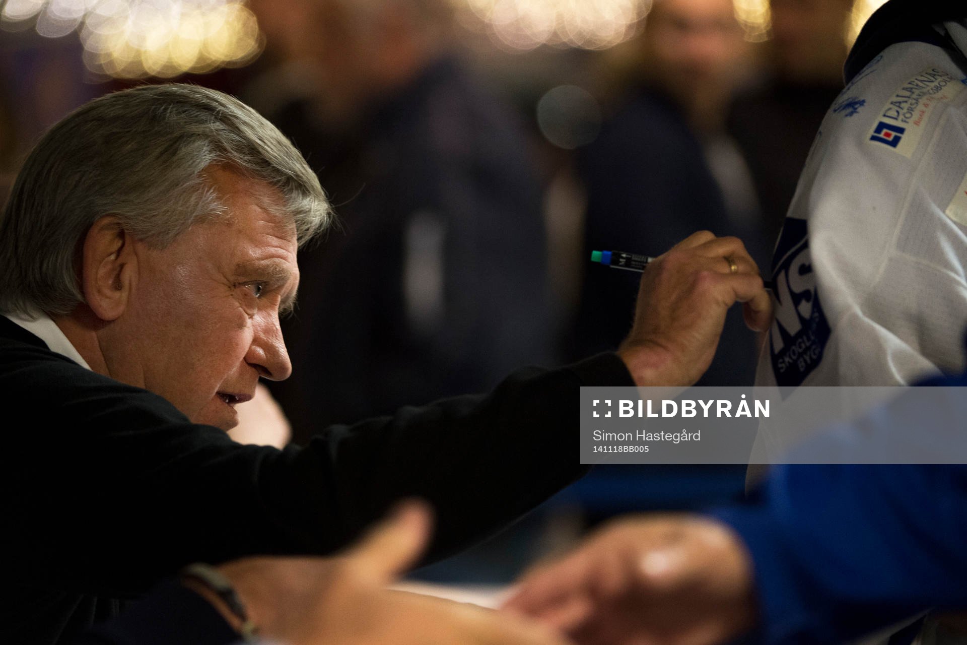 Hockeylegendaren Mats Åhlberg signerar tröja före