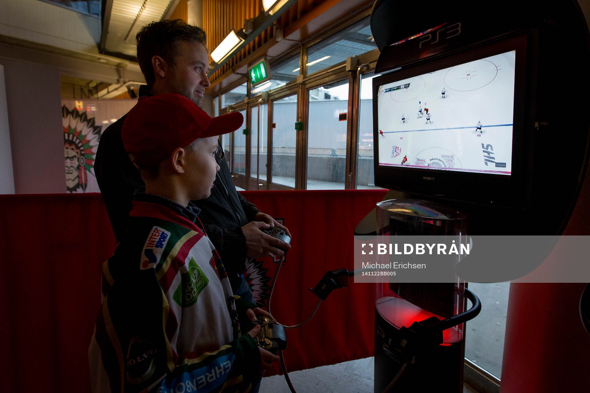 Far och son spelar en match på Playstation innan