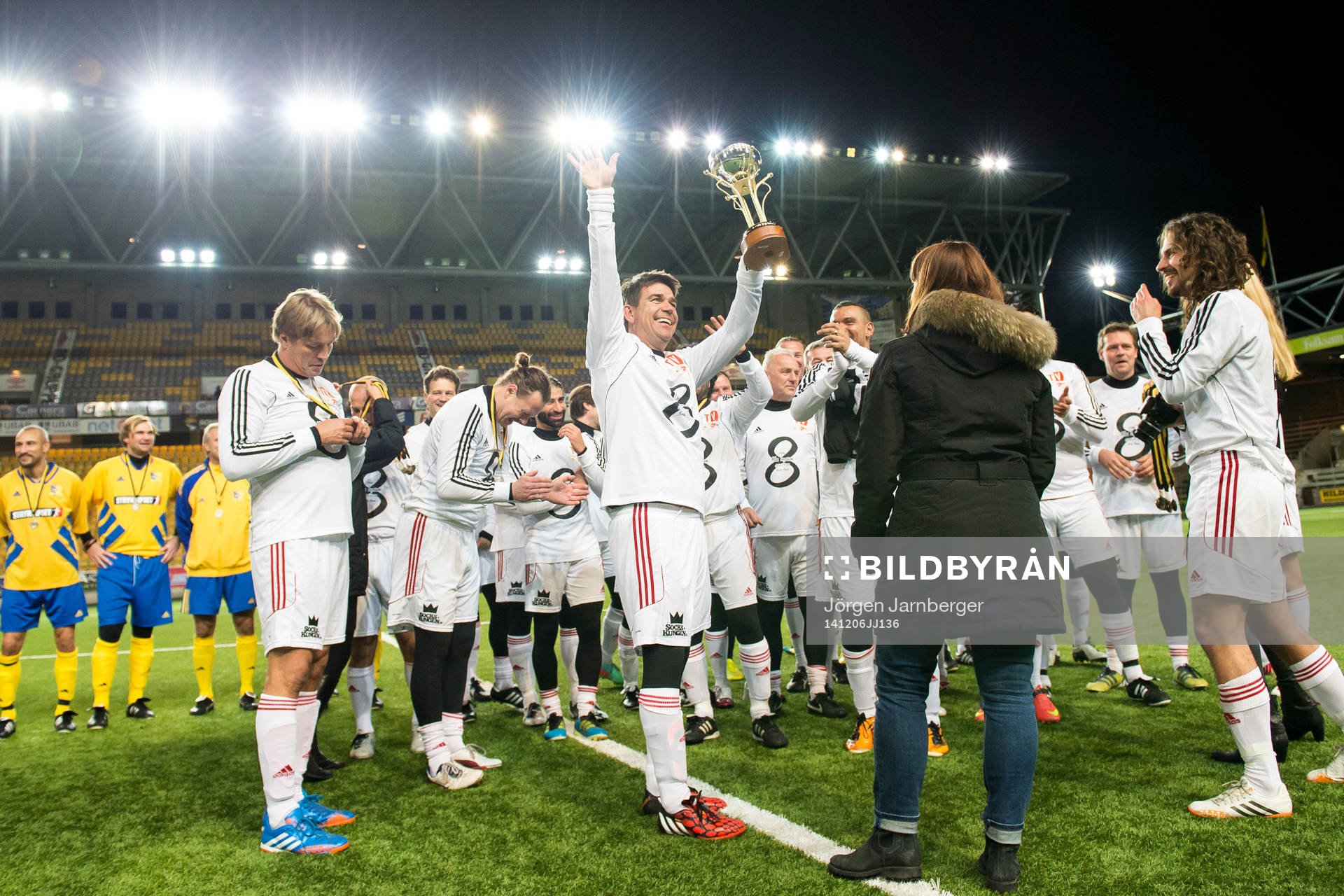 TV-lagets Patrik Ekwall höjer pokalen och laget jublar efter seger i Hedra Klas Ingessons fotbollsturnering den 6 december 2014 i Borås.