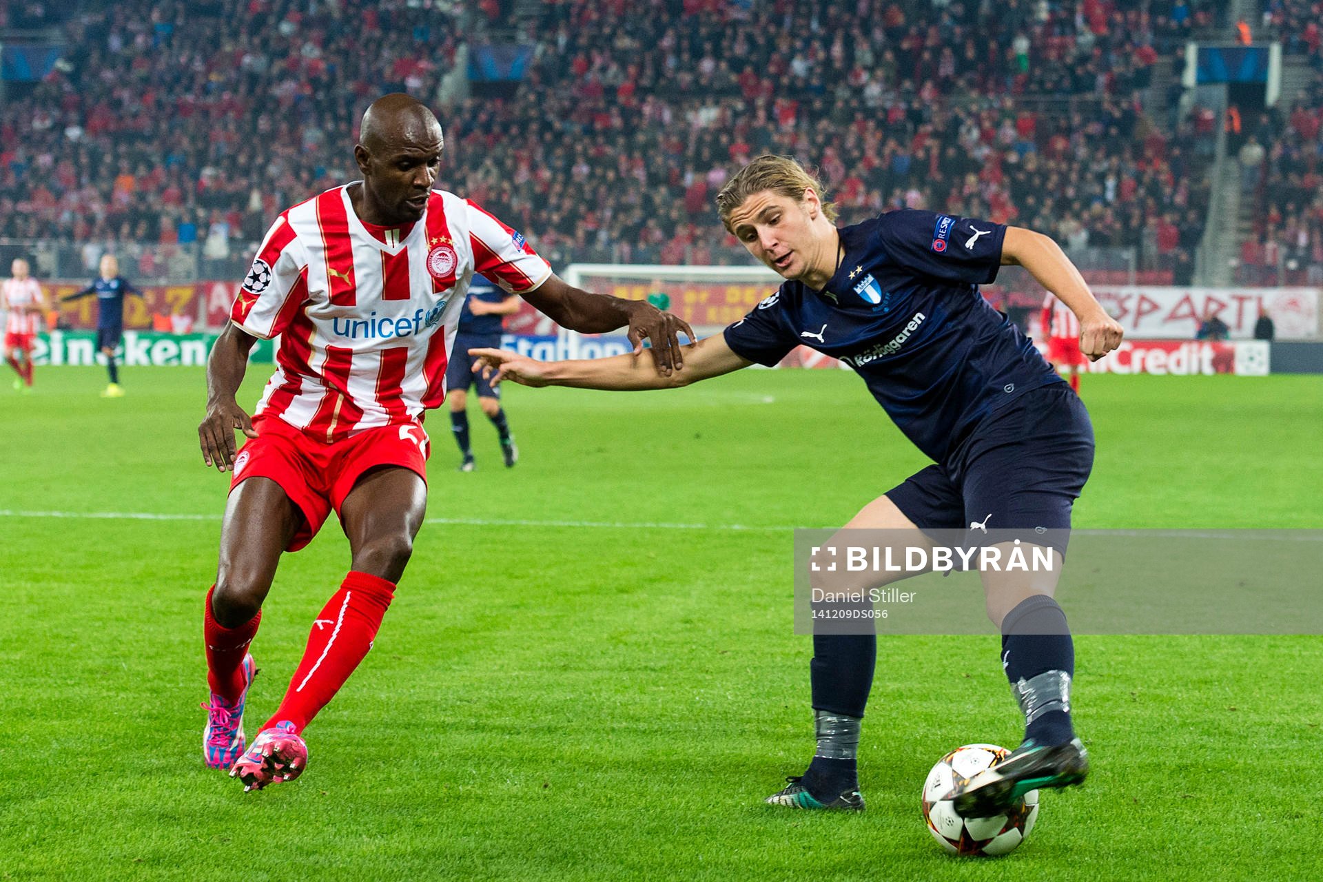 Malmö FFs Pawel Cibicki i kamps med Olympiacos Eric Abidal under fotbollsmatchen i Champions League mellan Malmö FF och Olympiakos den 9 december 2014 i Aten, Grekland.