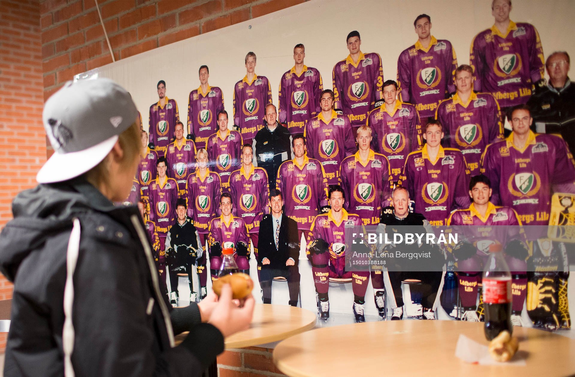 En supporter studerar ett äldre lagfoto på Färjestad