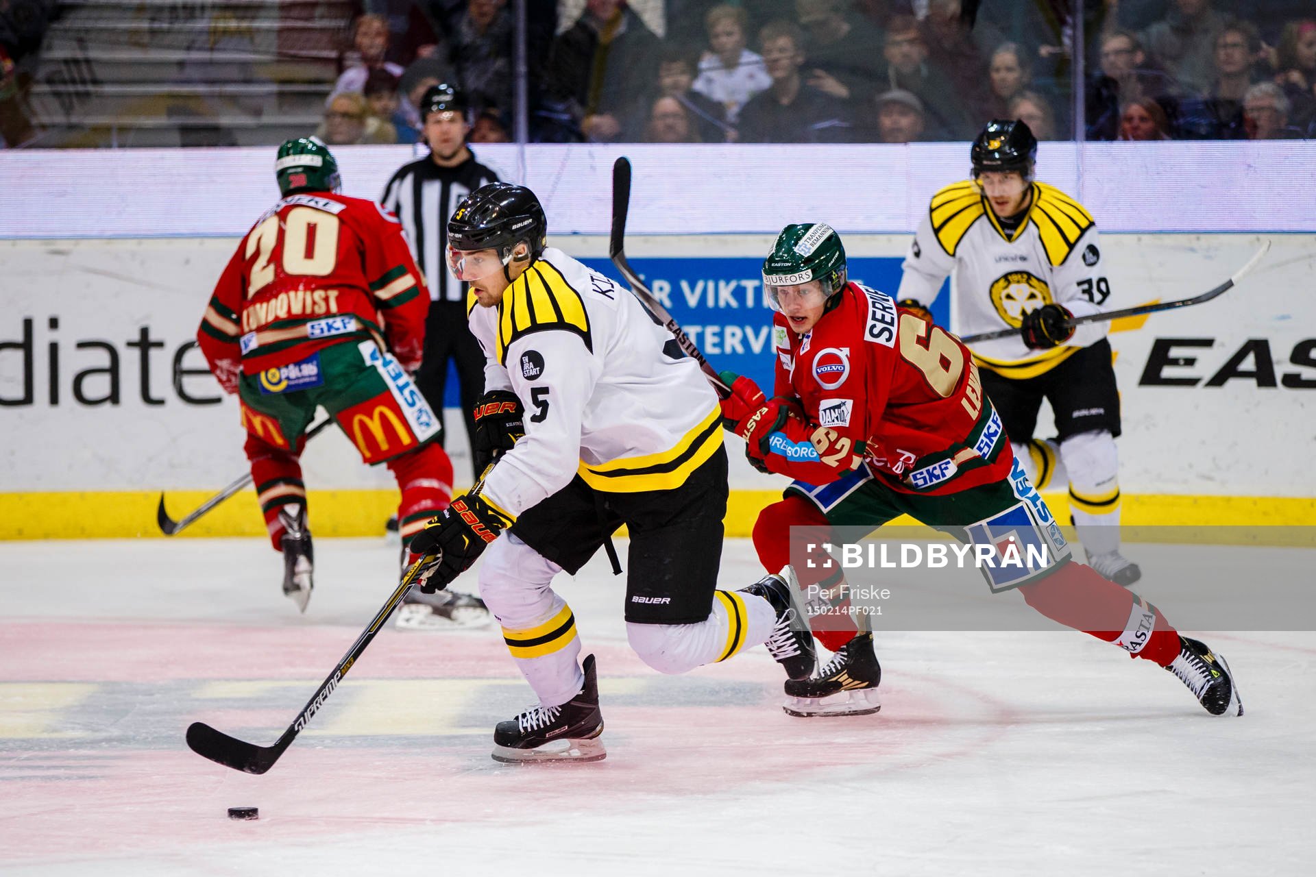 Brynäs Lukas Kilström med pucken jagas av Frölundas