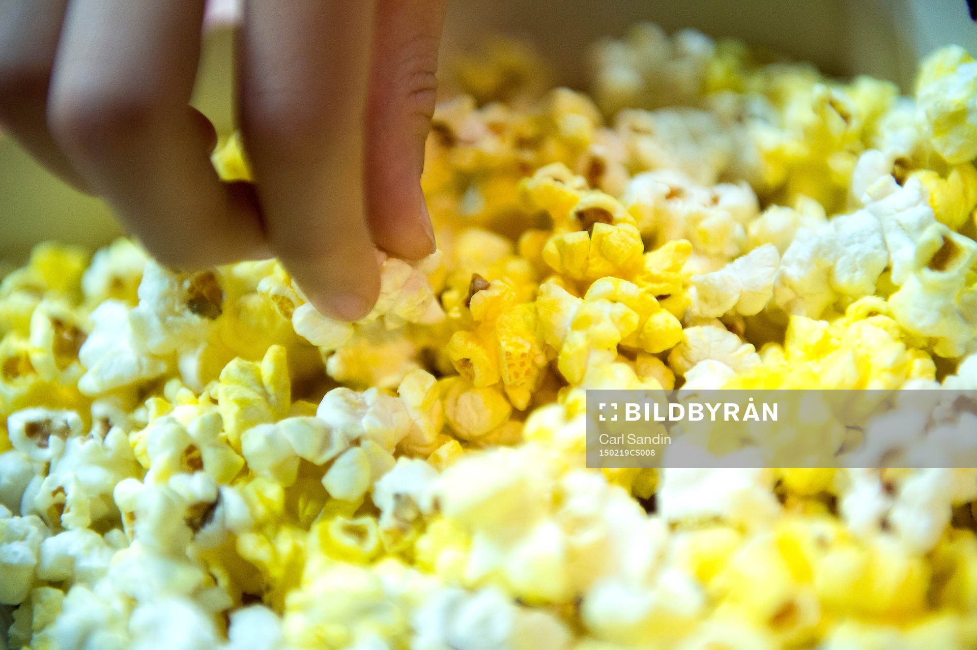 En person äter popcorn
