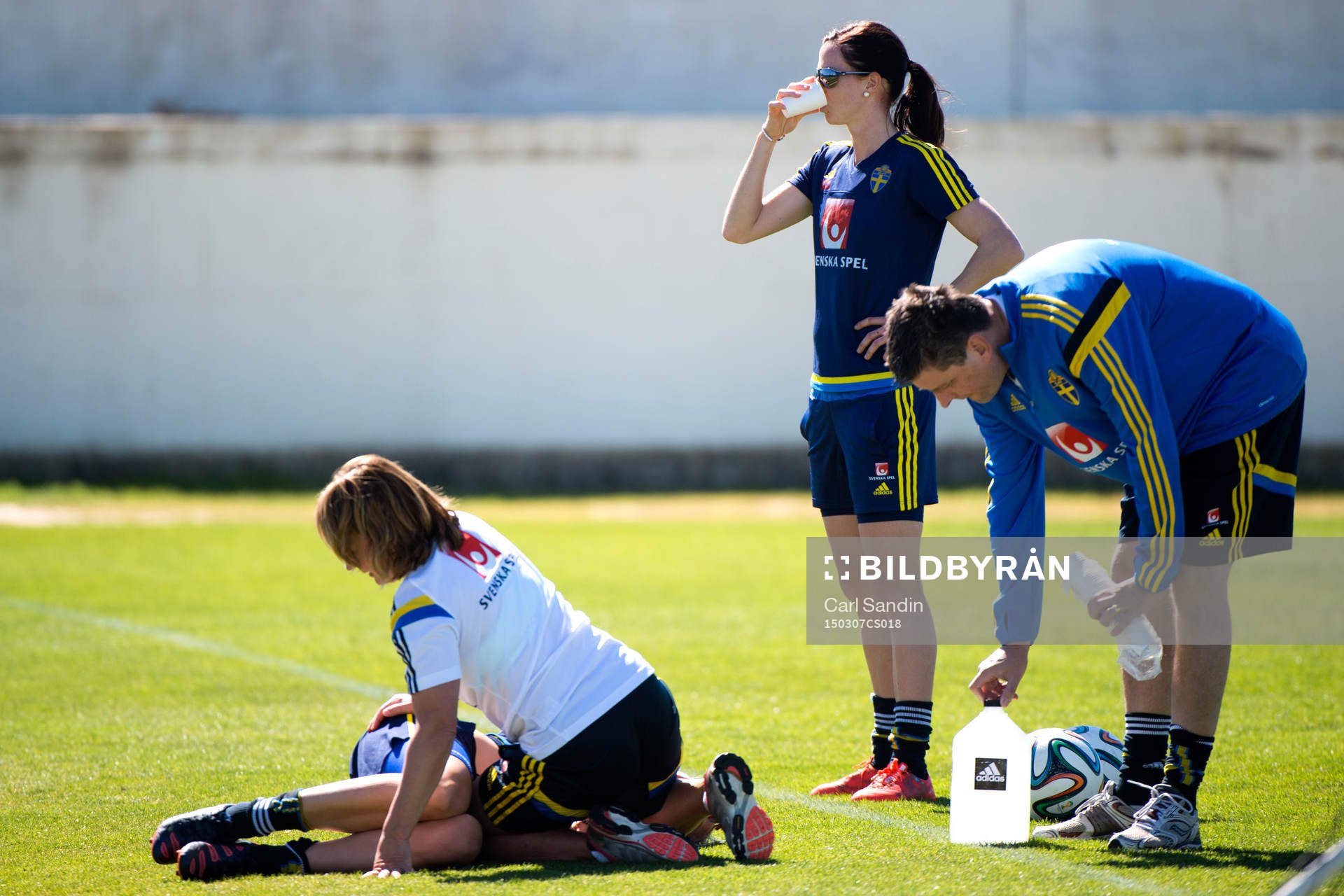 Sveriges Caroline Seger får behandling av sjukgymnast Annica Näsmark samtidigt som Lotta Schelin får vatten av läkare Mats Börjesson under en träning med det svenska landslaget i fotboll den 7 mars 2015 i Ferreiras.