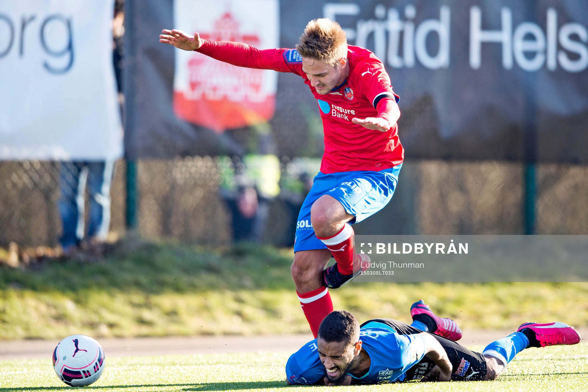 Halmstads Junes Barny faller i kamp med Helsingborgs Johan Mårtensson under fotbollsmatchen i Svenska Cupen mellan Helsingborg och Halmstad den 8 mars 2015 i Helsingborg.