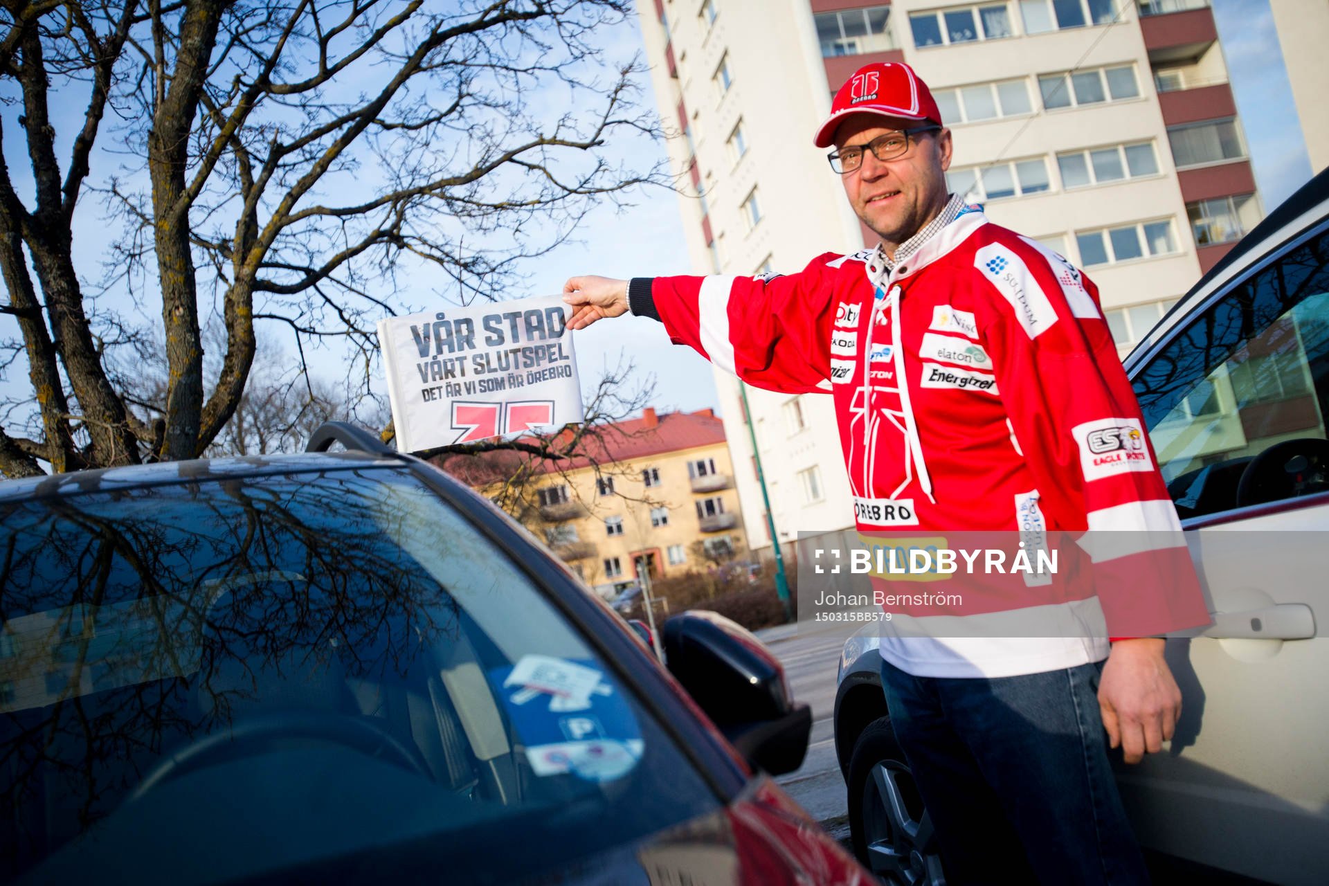 Örebrosupporter håller upp en bilvimpel med texten Vår