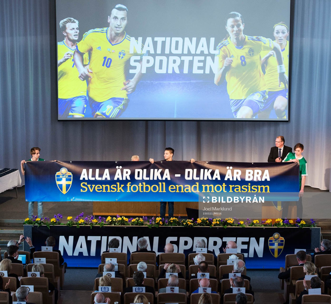 Pojkar håller upp en banderoll för temat Alla är olika