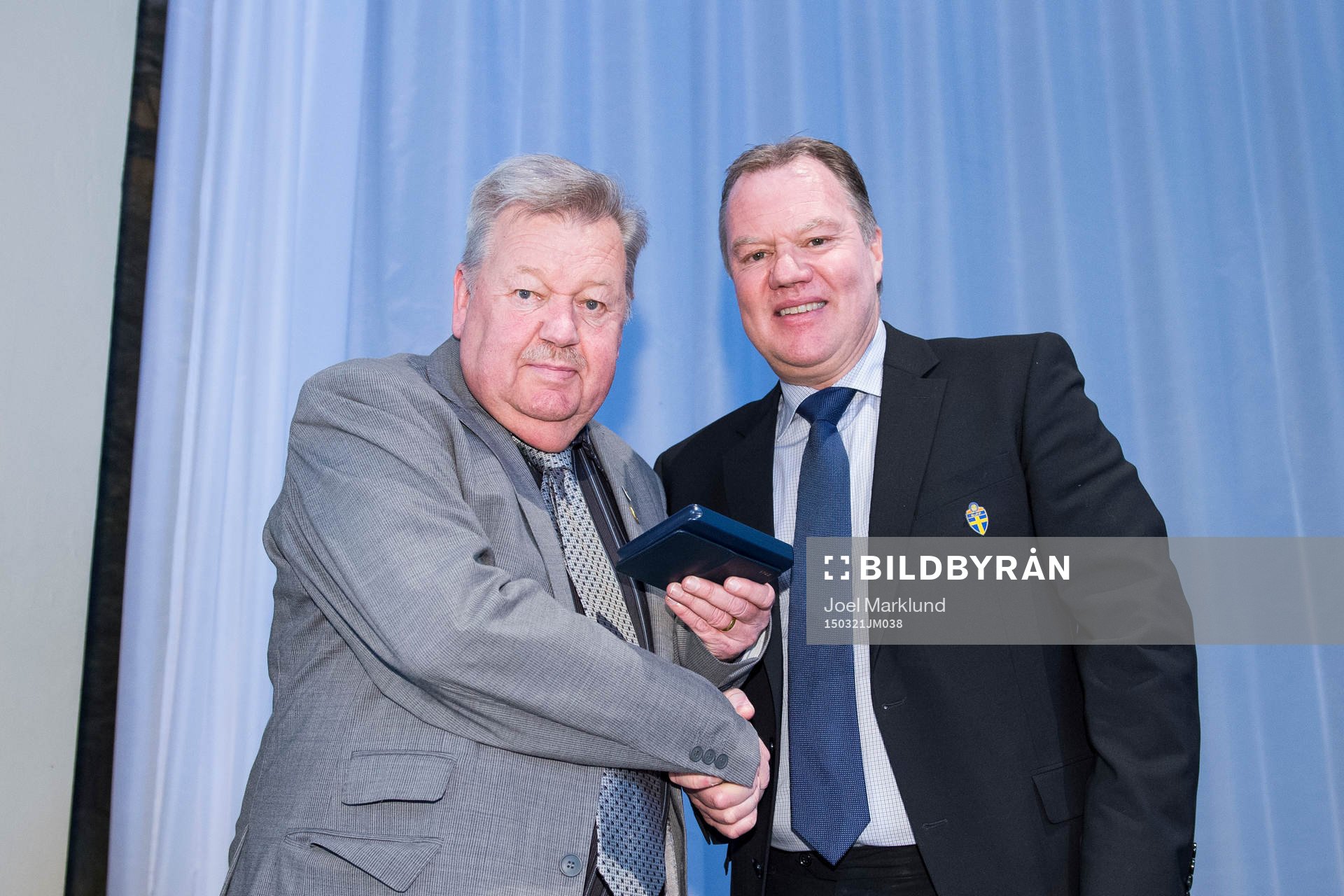 Jan Hagman tar emot en medalj för sina insatser för svensk fotboll av ordförande Karl-Erik Nilsson under Svenska Fotbollförbundets årsmöte den 21 mars 2015 i Stockholm.