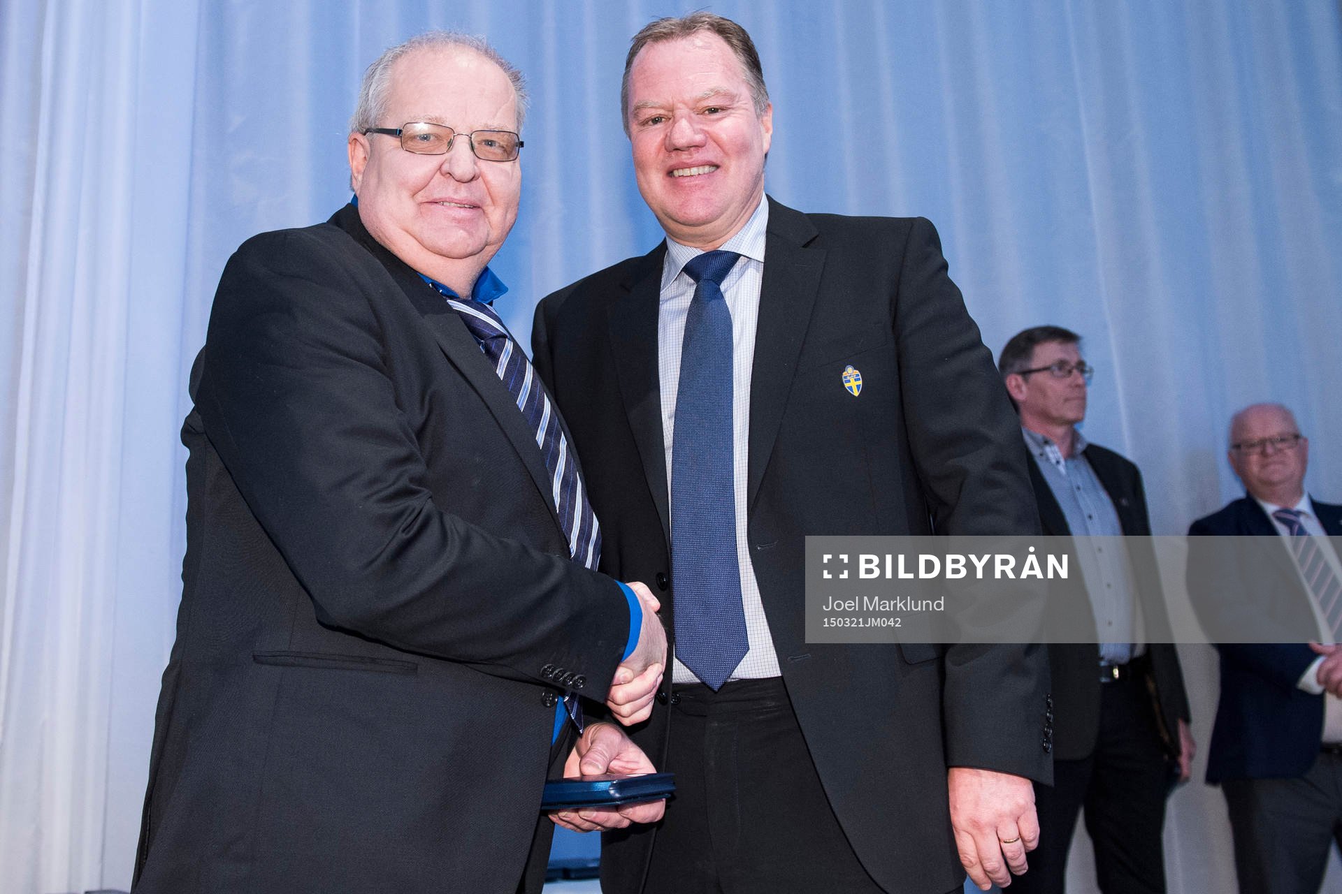 Åke Johansson tar emot en medalj för sina insatser för