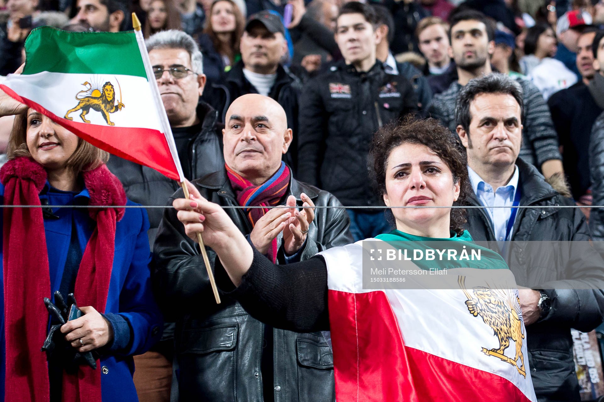 Iranska supportrar håller upp en flagga med ett lejon på