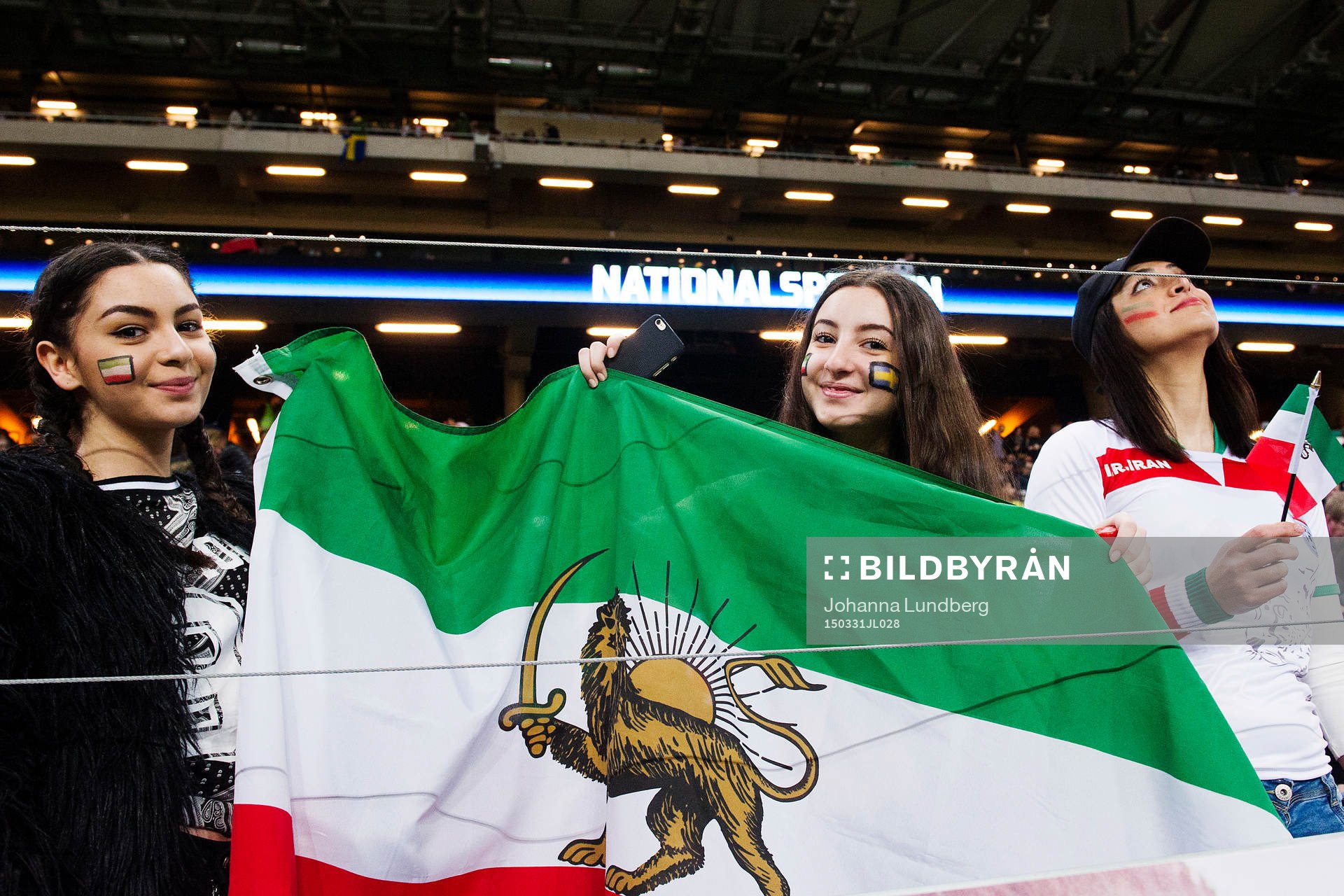 Supportrar håller upp en Iransk flagga med ett lejon på