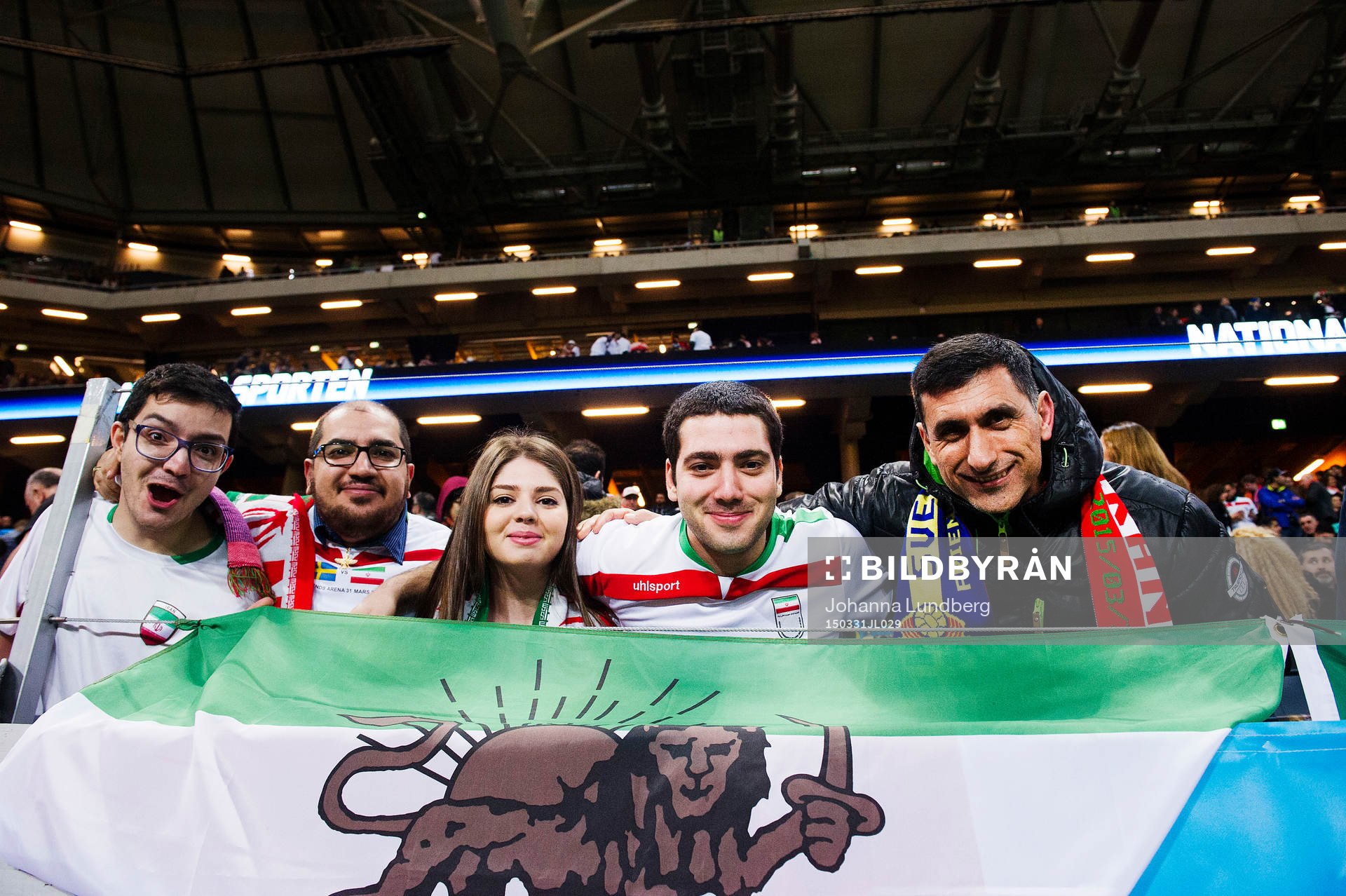 Supportrar håller upp en Iransk flagga med ett lejon på