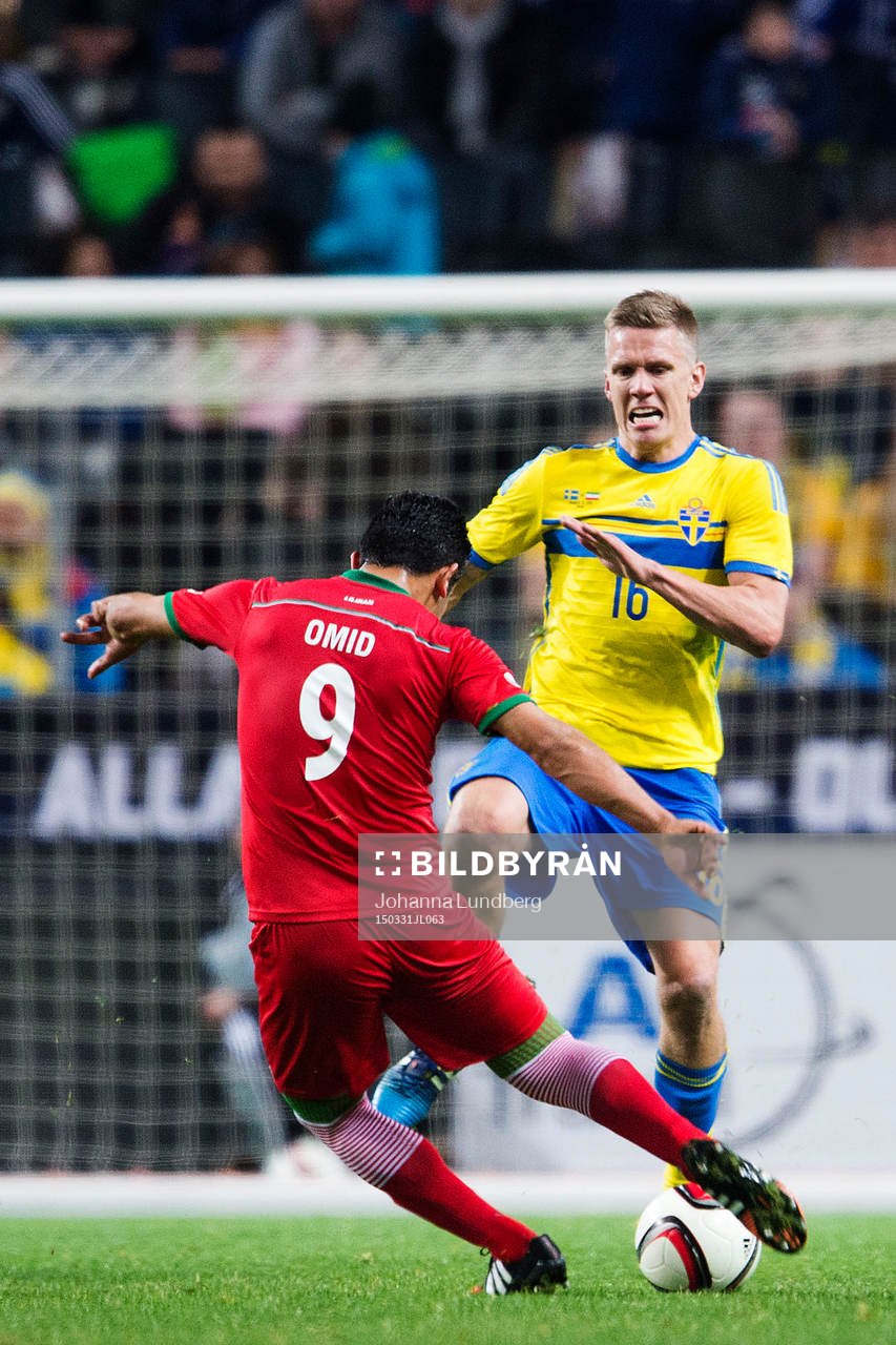 Sveriges Pontus Wernbloom försöker stoppa Irans Omid Ebrahimi under fotbollslandskampen mellan Sverige och Iran den 31 mars 2015 i Stockholm. 
