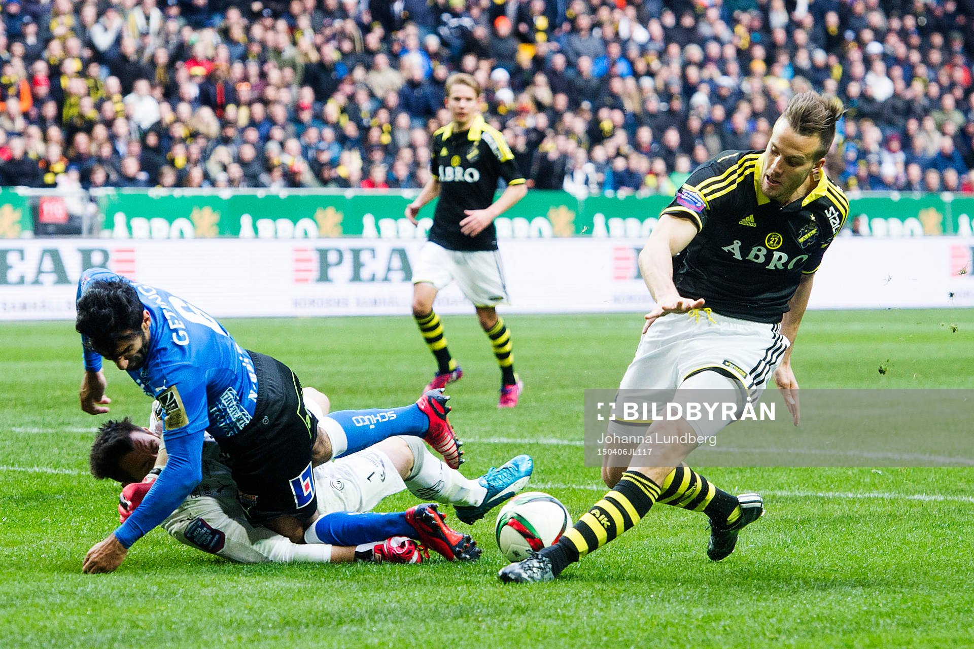 Halmstads Mohammed Ali Khan faller över målvakt Stojan Lukic med AIK:s Fredrik Brustad under fotbollsmatchen i Allsvenskan mellan AIK och Halmstad den 6 april 2015 i Stockholm.