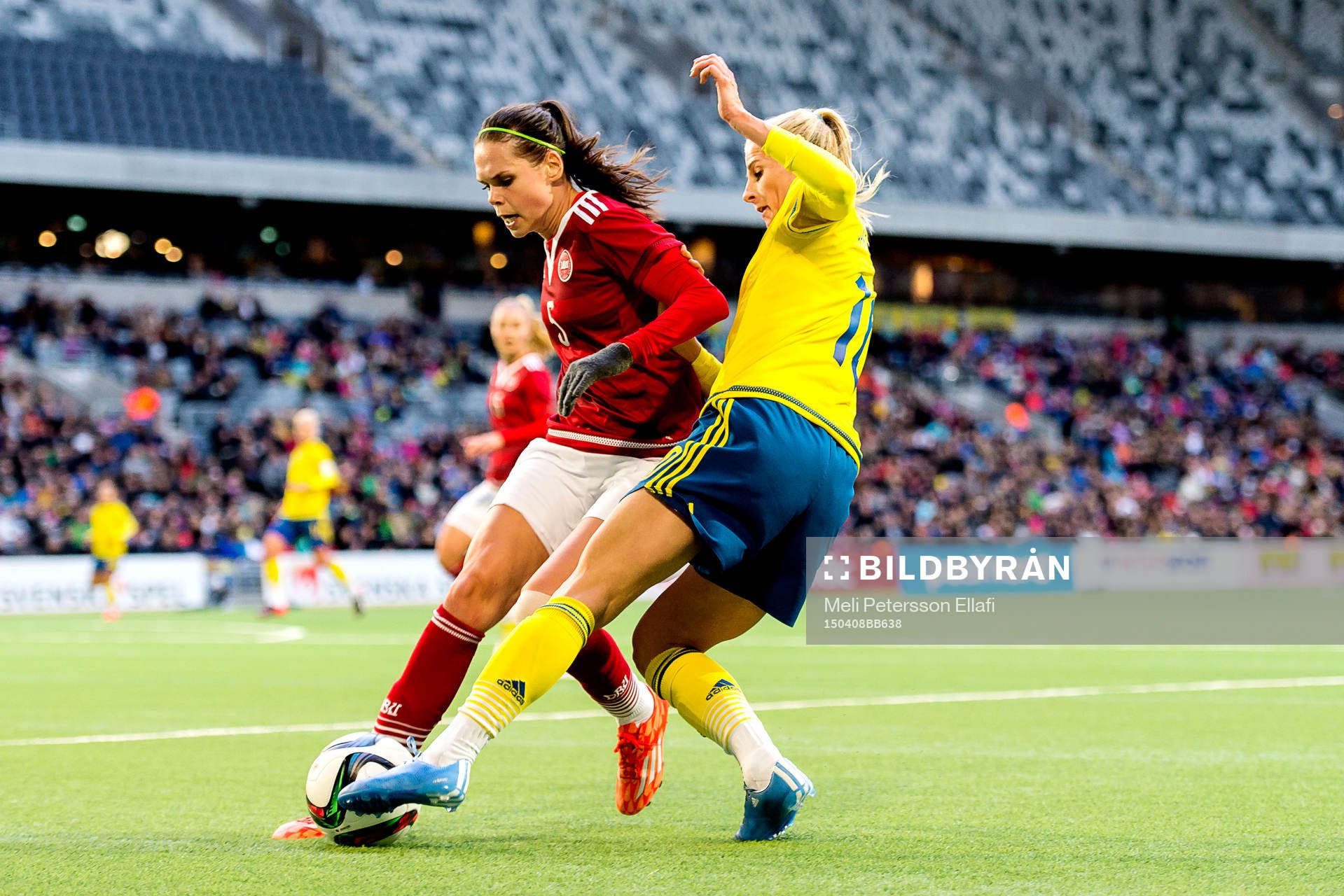 Sveriges Sofia Jakobsson i en närkamp med Danmarks Simone Boye Sørensen under fotbollslandskampen mellan Sverige och Danmark den 8 april 2015 i Stockholm.